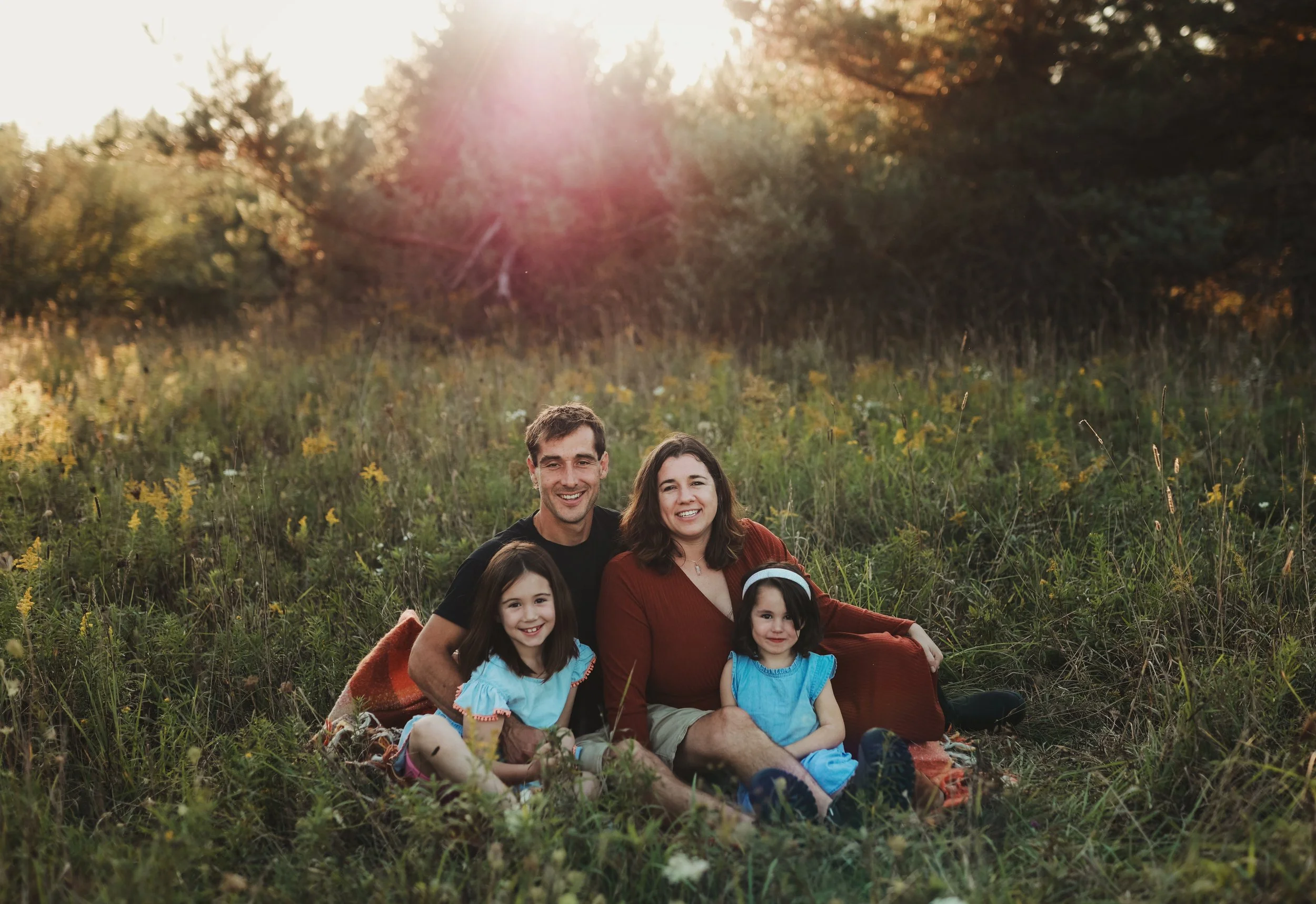 Nicole and Zachary Mezeske and their two children in a grassy field