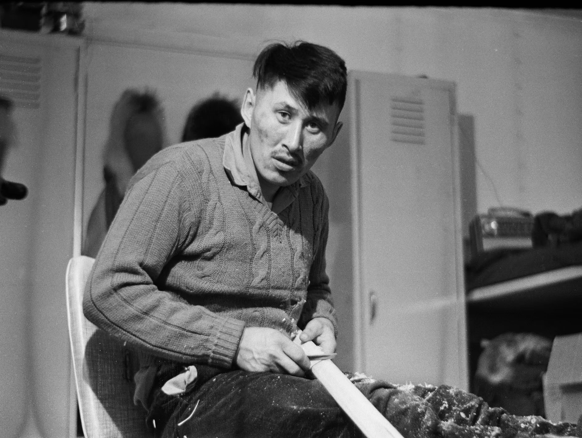 Tagruk Bodfish carves a kayak paddle in Richard's Wainwright home (1964).