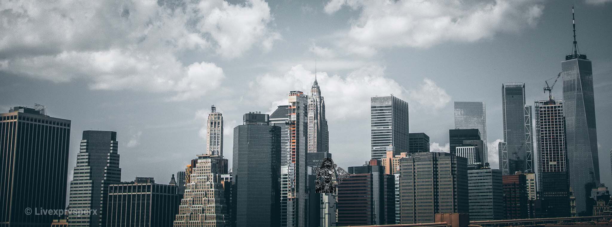 City skyline with tall skyscrapers under cloudy sky.