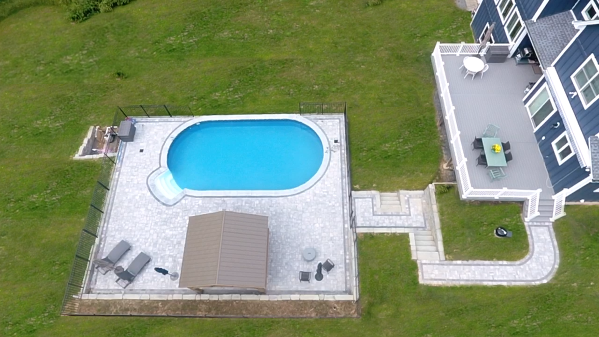 Inground pool surrounded by green lawn