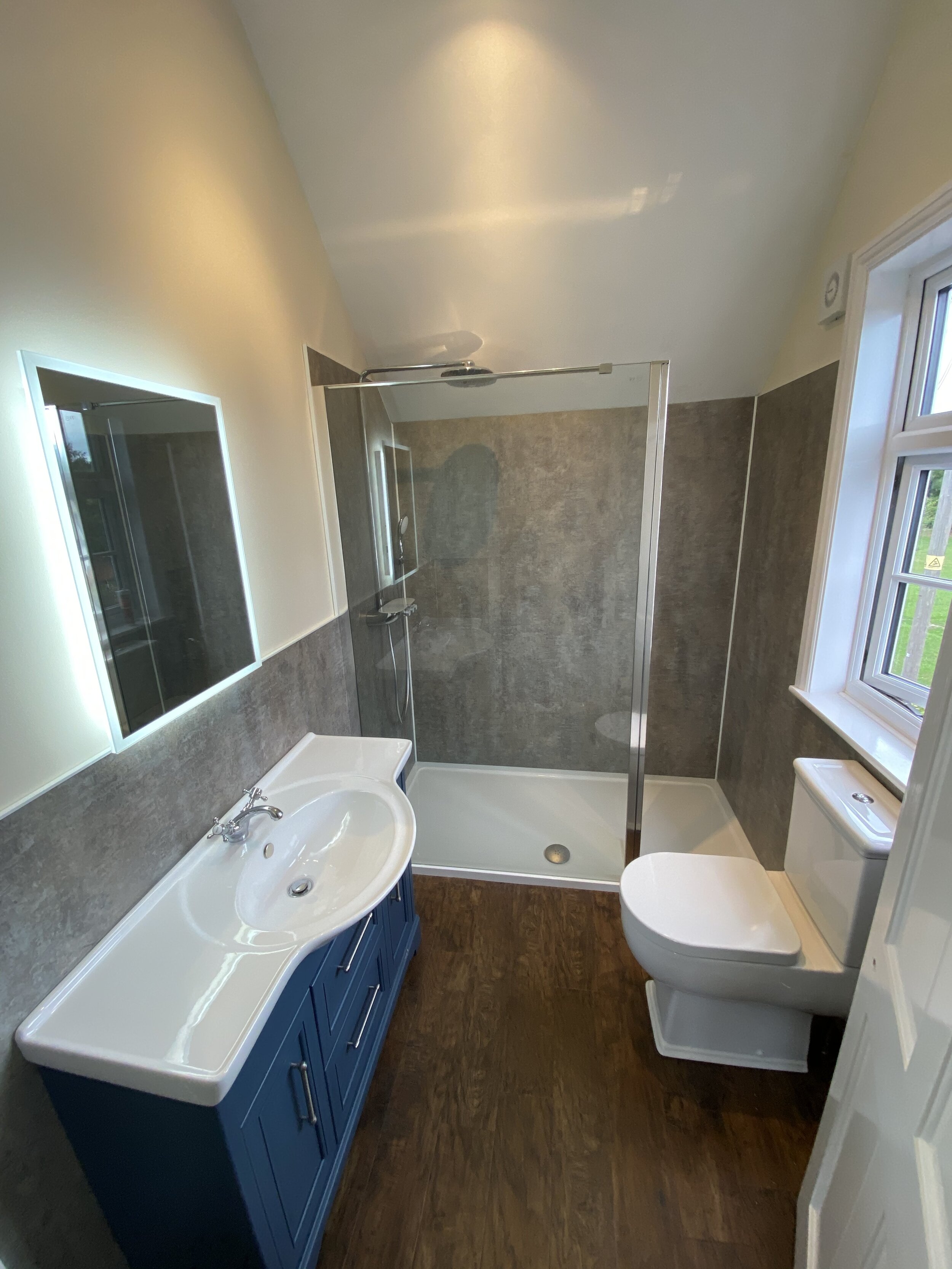 Bathroom installed by Cotswold Vale, featuring a blue wooden base to the sink unit.