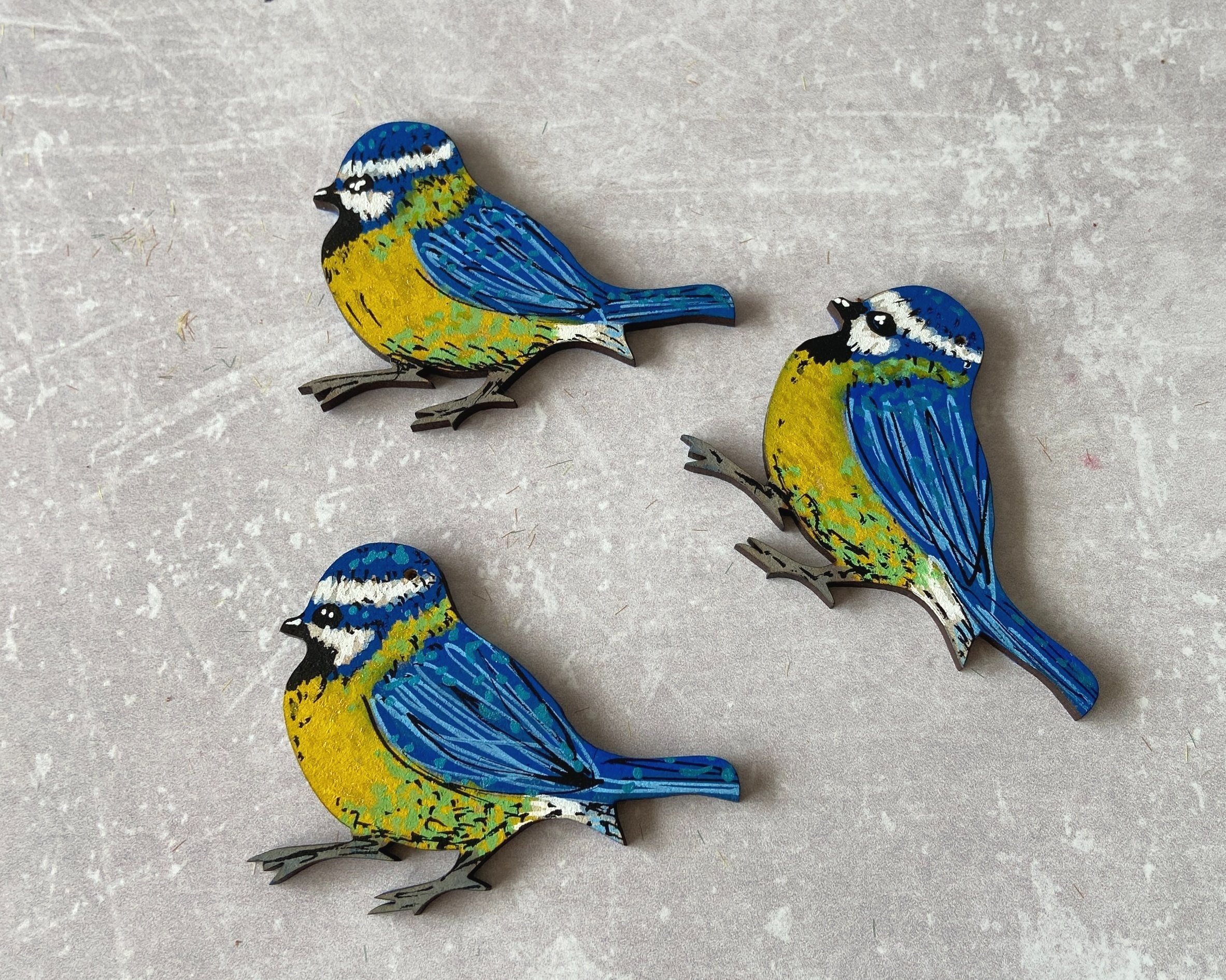 Hand-painted wooden blue tit decorations by Devon artist Helen Leslie Illustrator