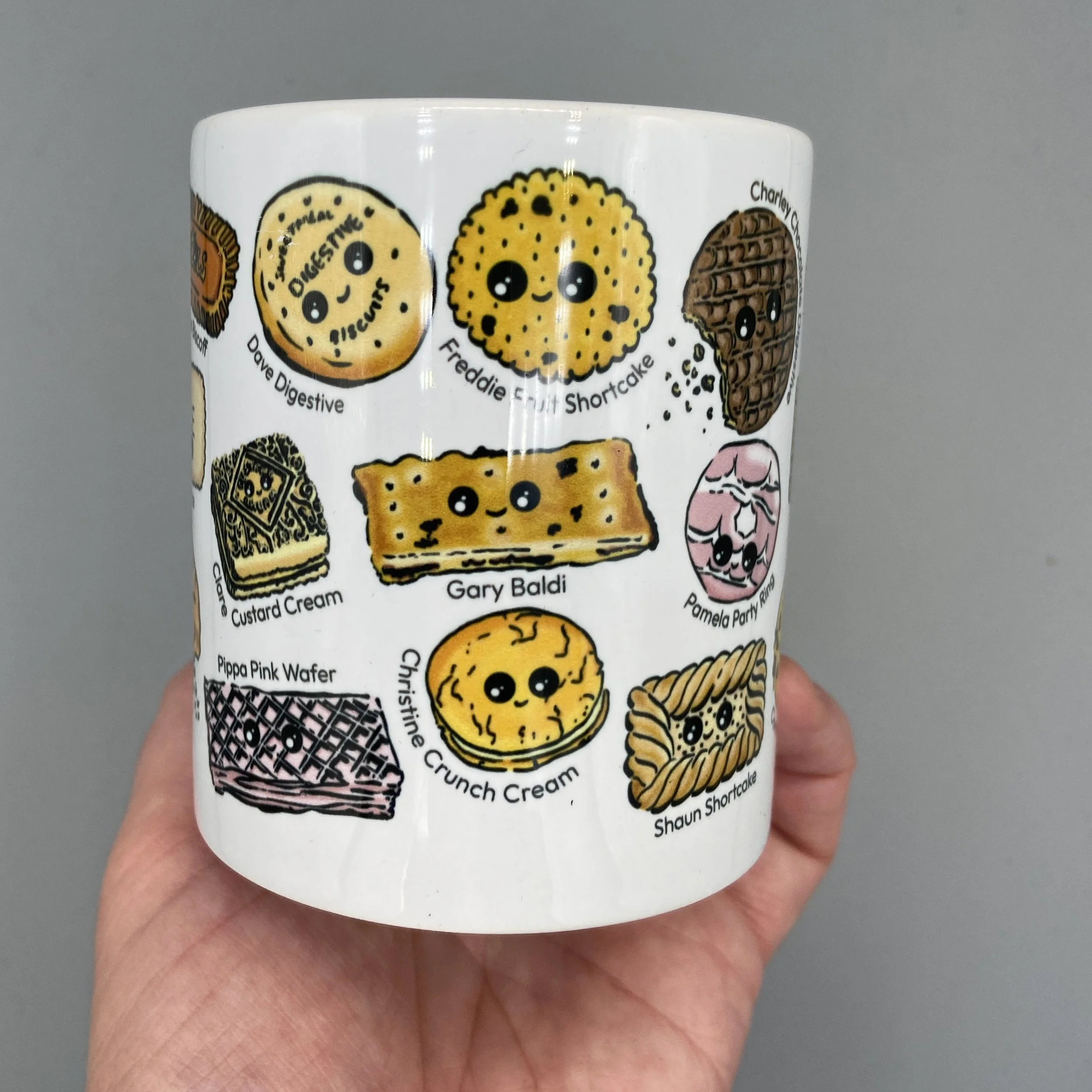 Biscuit Besties mug full of tea dunking favourite biscuits with alliterative names for a splash of humour! Perfect for a nice cup of tea. By Devon artist Helen Leslie Illustrator