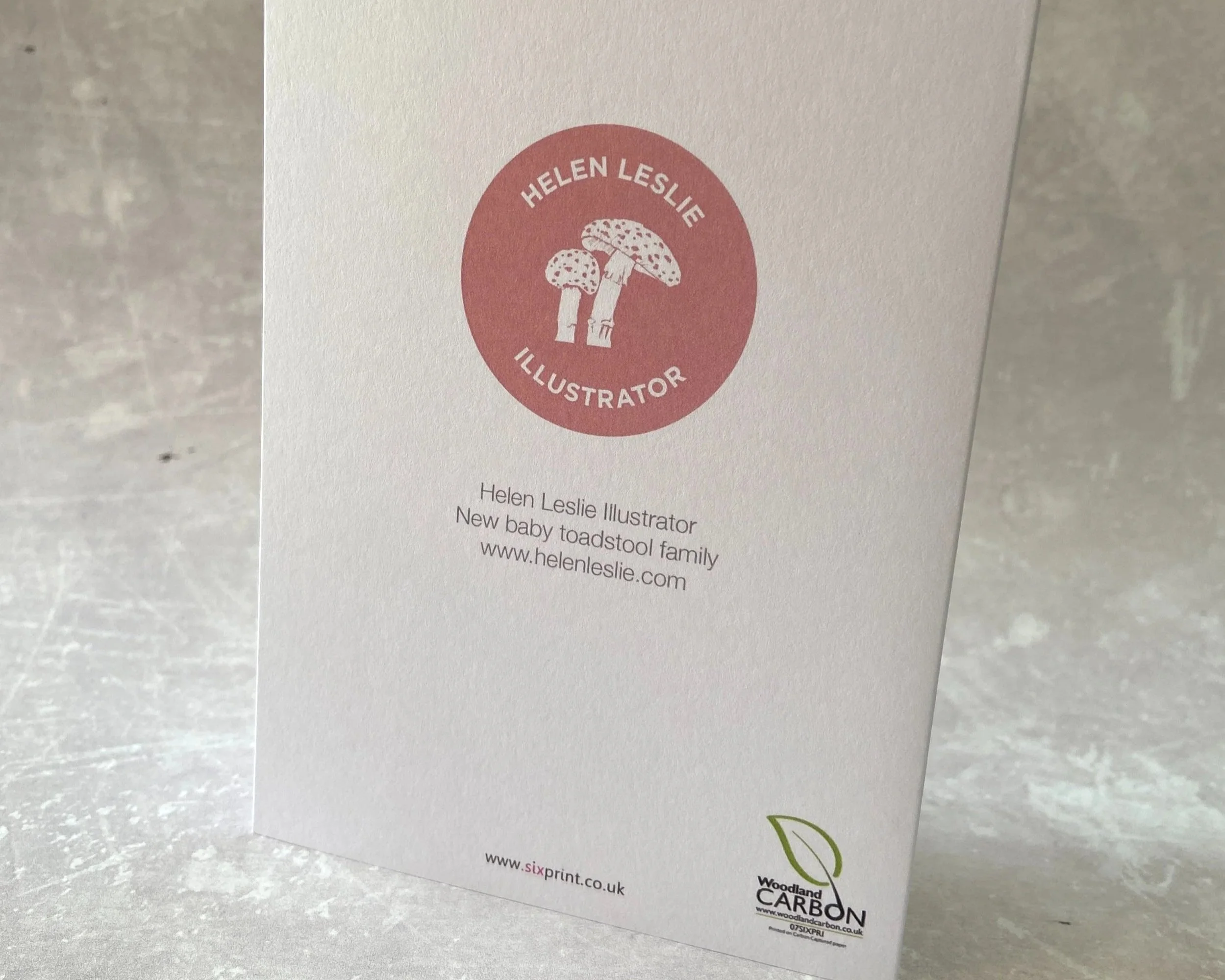 Congratulations on the birth of your new baby greetings card illustrated cute toadstool family with baby. Unisex card for baby boys or baby girls. By Devon artist Helen Leslie Illustrator