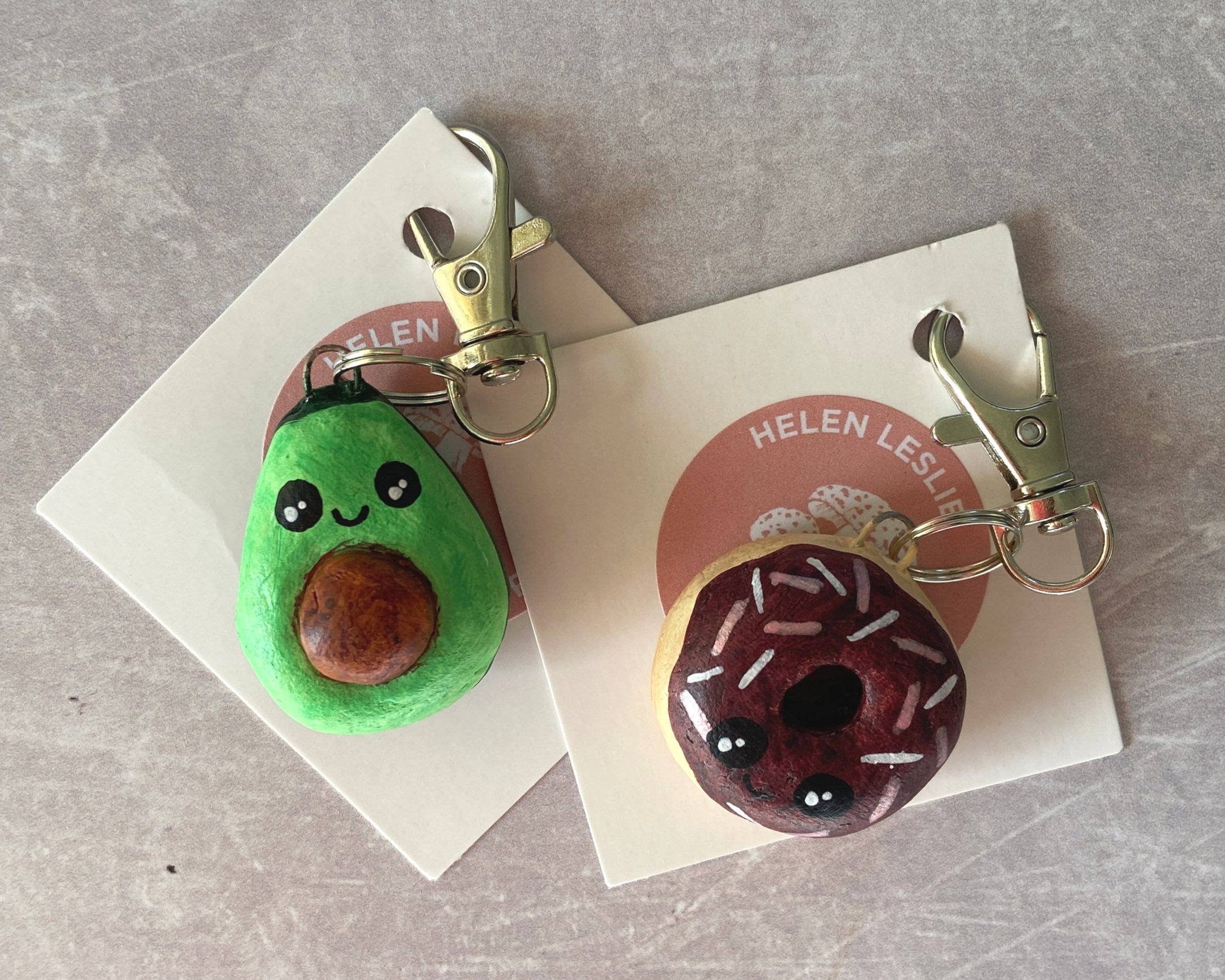 Cute doughnut and avocado handmade clay bag charms, keyrings by Devon artist Helen Leslie Illustrator