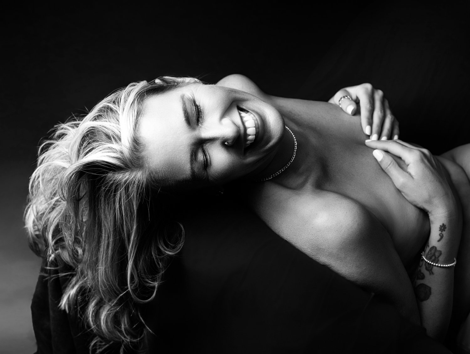 Woman embracing body confidence during a boudoir photoshoot