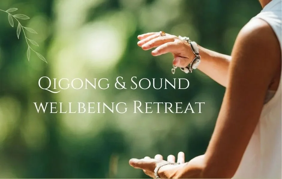 Qigong pose with hands around an imaginary ball against a nature background