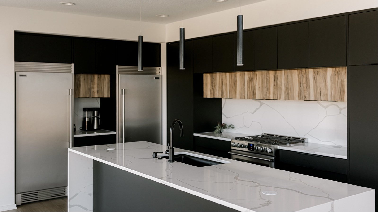 black custom-built kitchen cabinets and dual refridgerators