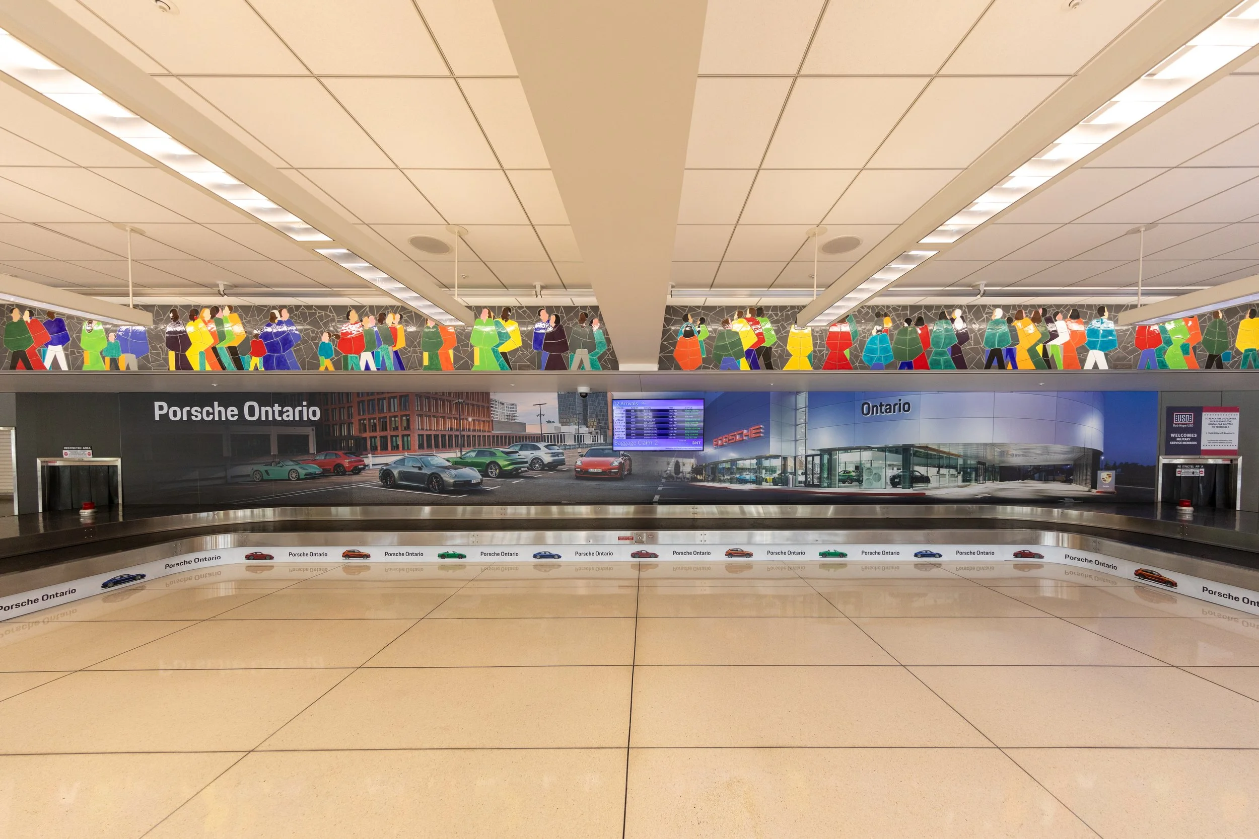 A full-width Porsche Ontario branded display wrapping the baggage claim carousel at Ontario International Airport, featuring large-format imagery of the dealership and vehicle lineup alongside repeated Porsche Ontario branding on the carousel belt.