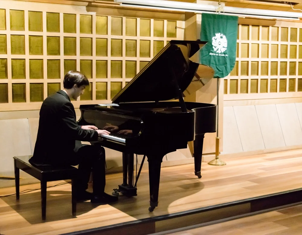 Alec Vera toca el piano en evento organizado por Martes de Ópera. 