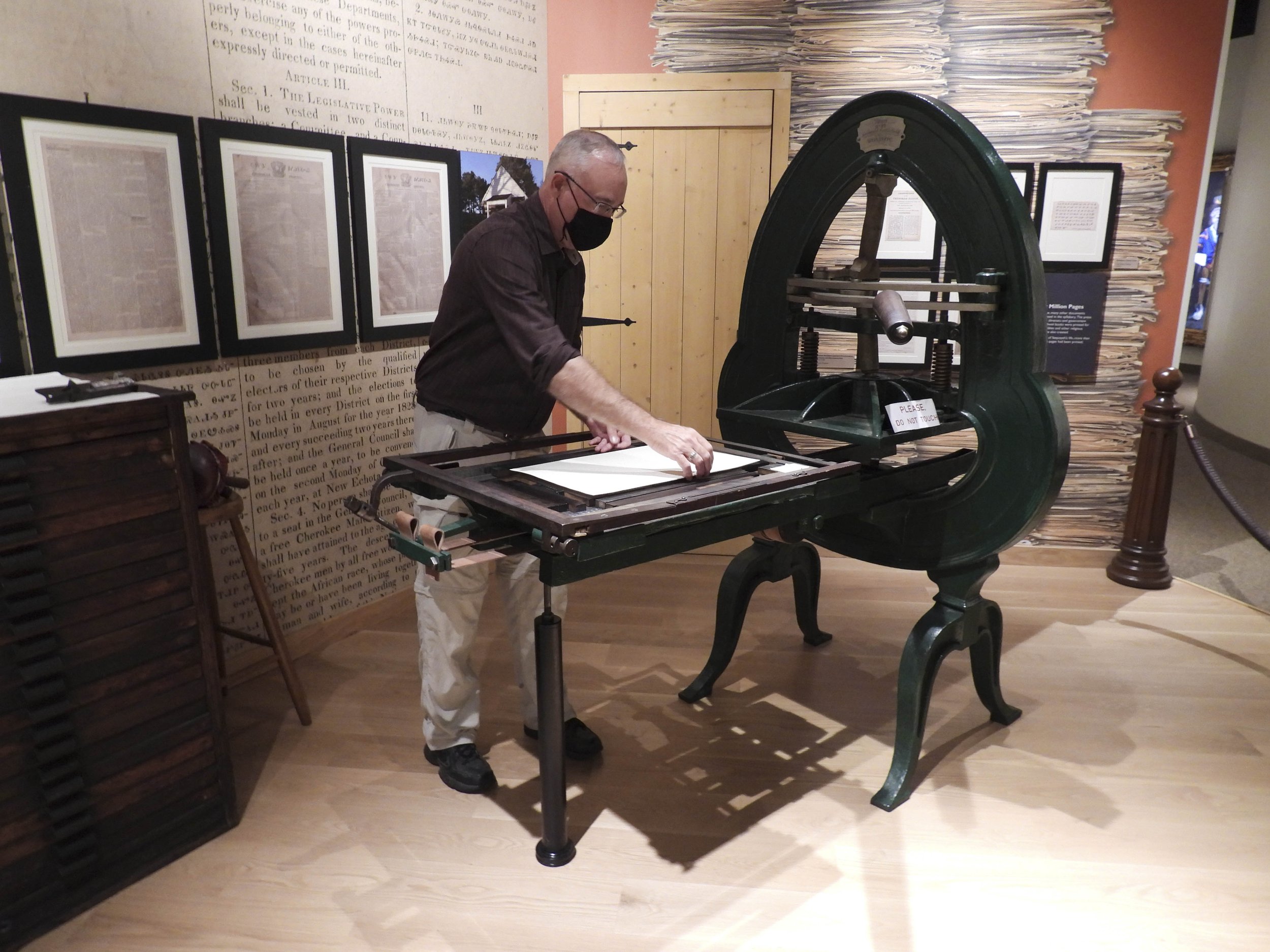 Charley Rotarmer, director of the Sequoyah Birthplace Museum, demonstrating the printing of the syllabary.