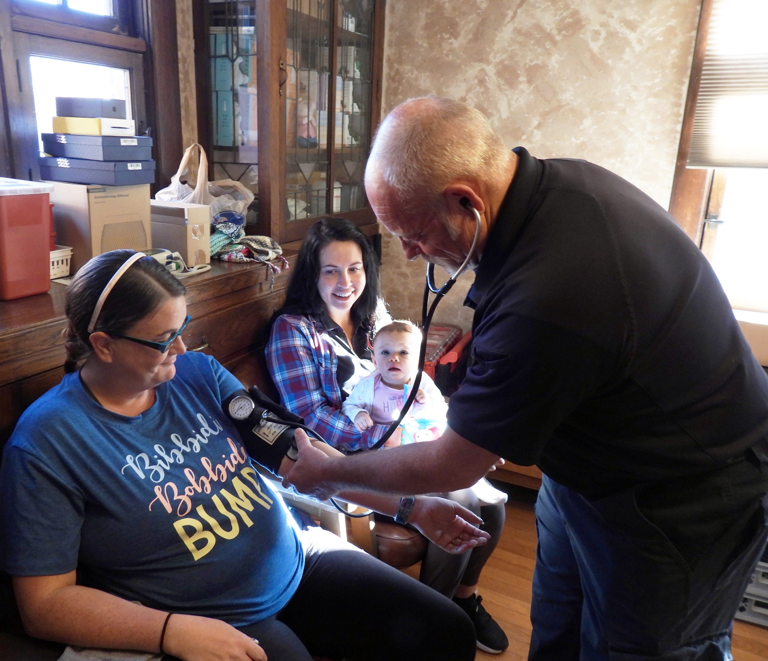 Darren Foreman and nurse treating mother , Kristy, in clinic.