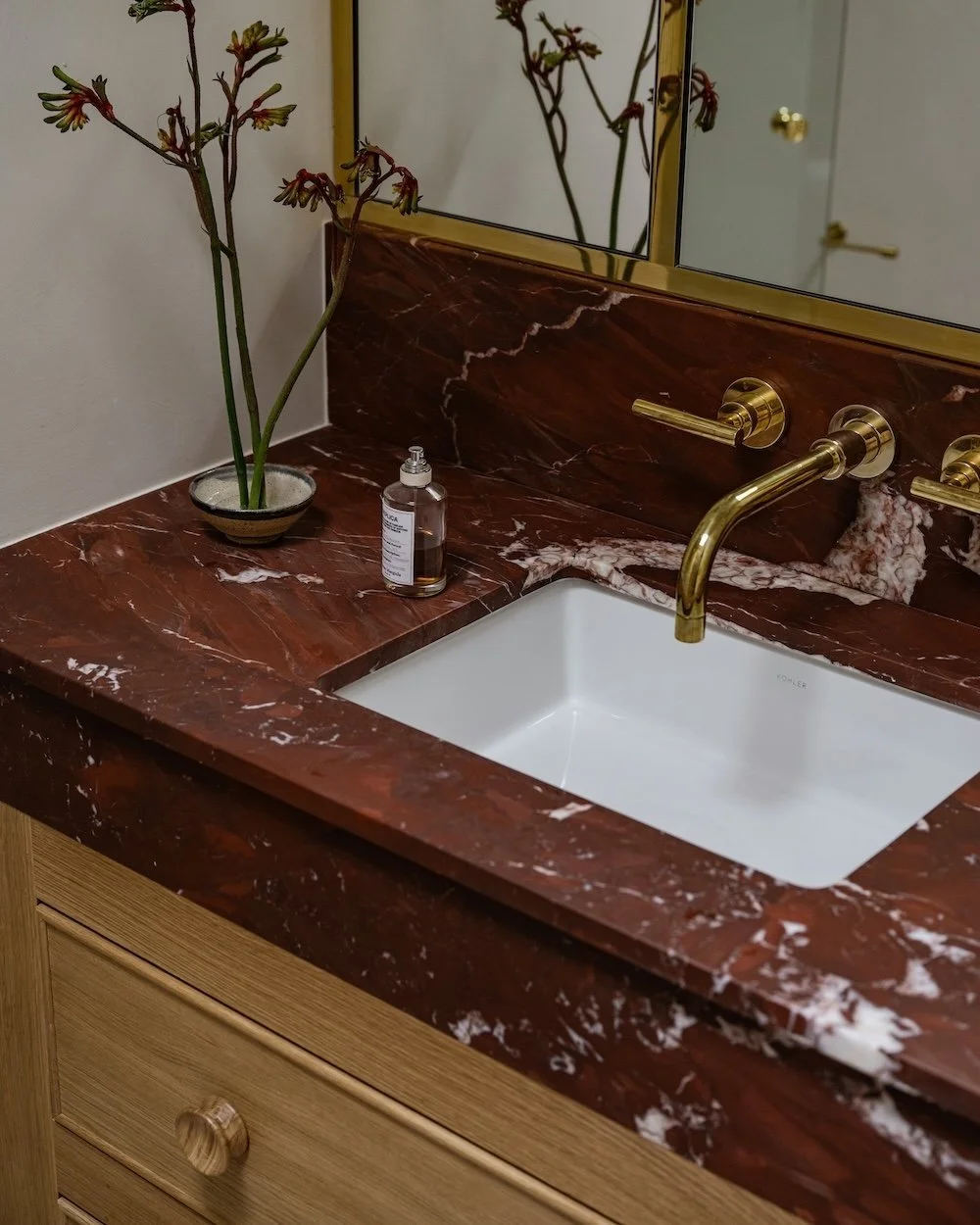 Red marble bathroom counter with brass accents.jpg