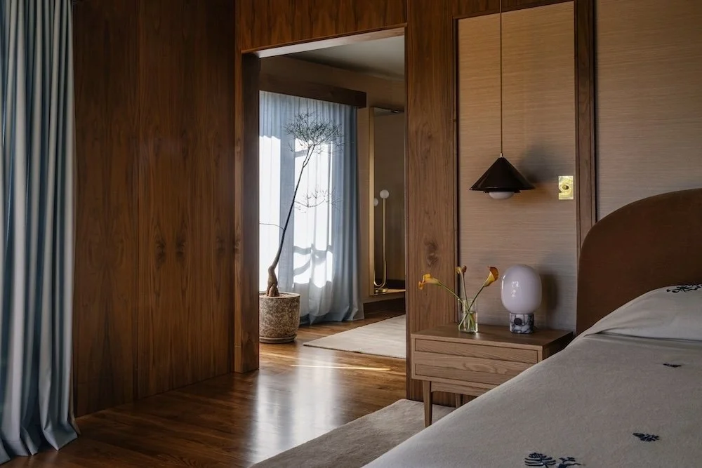Primary bedroom with walnut and grasscloth walls.jpg