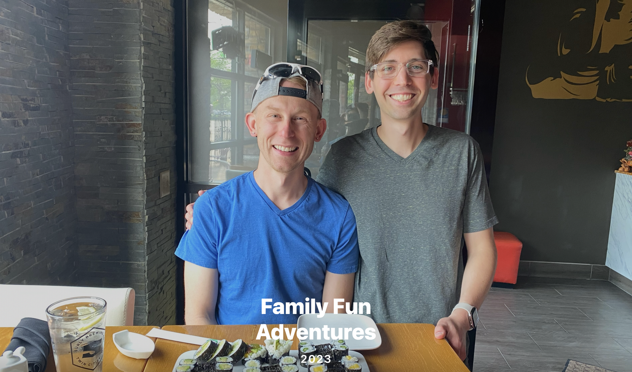 Two young men smiling in a restaurant, with sushi, drinks, and utensils on the table, and text overlay saying "Family Fun Adventures 2023."