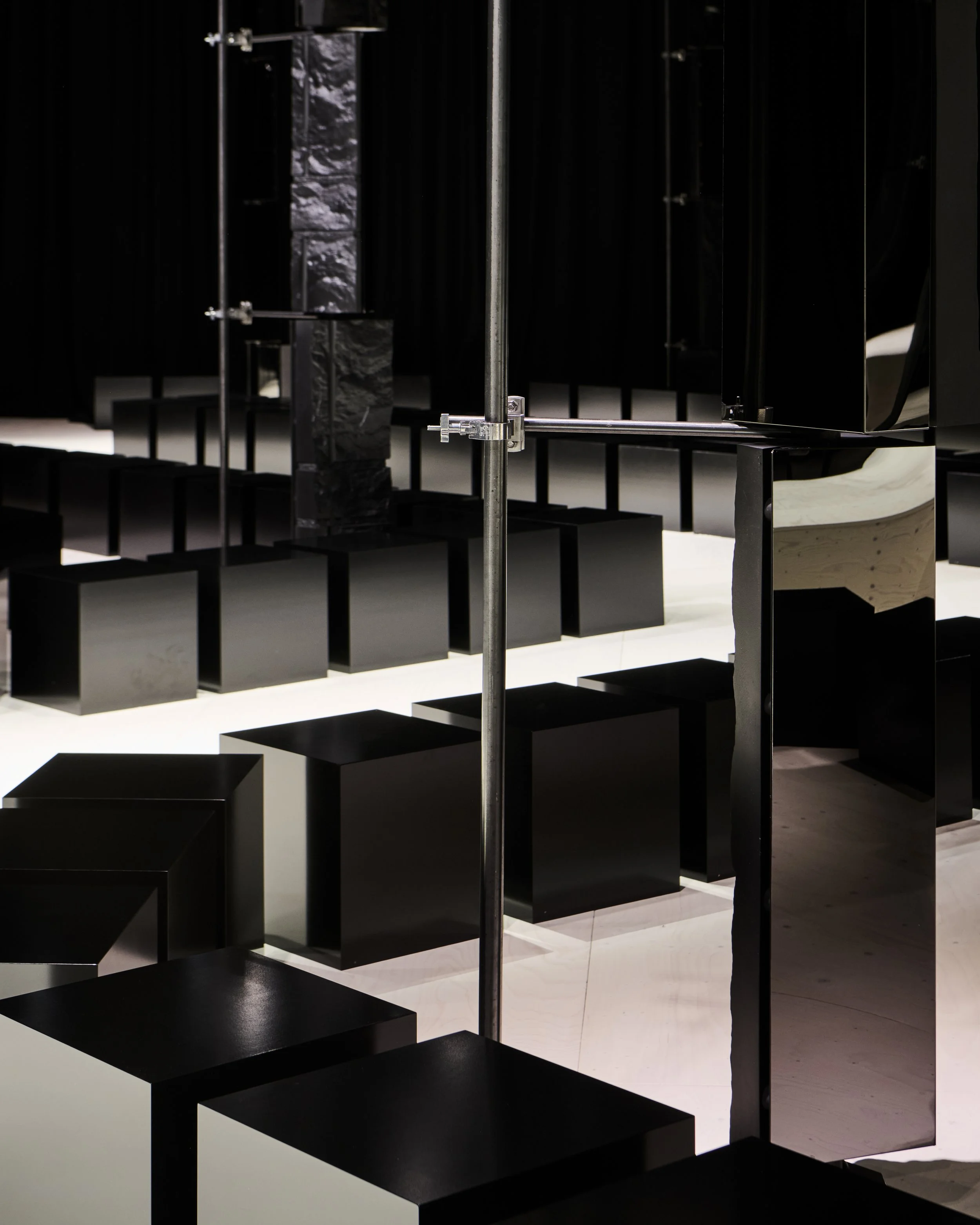 Black block seating along the runway between mirrored columns, Givenchy Fall/Winter 2026 show, Sarah Burton