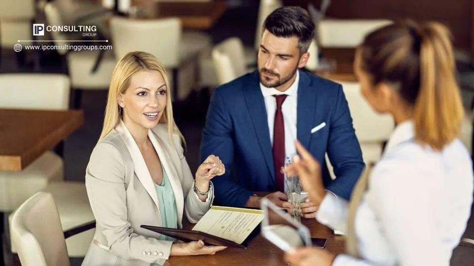 A man and woman in business attire engage in a conversation, appearing focused and professional.
