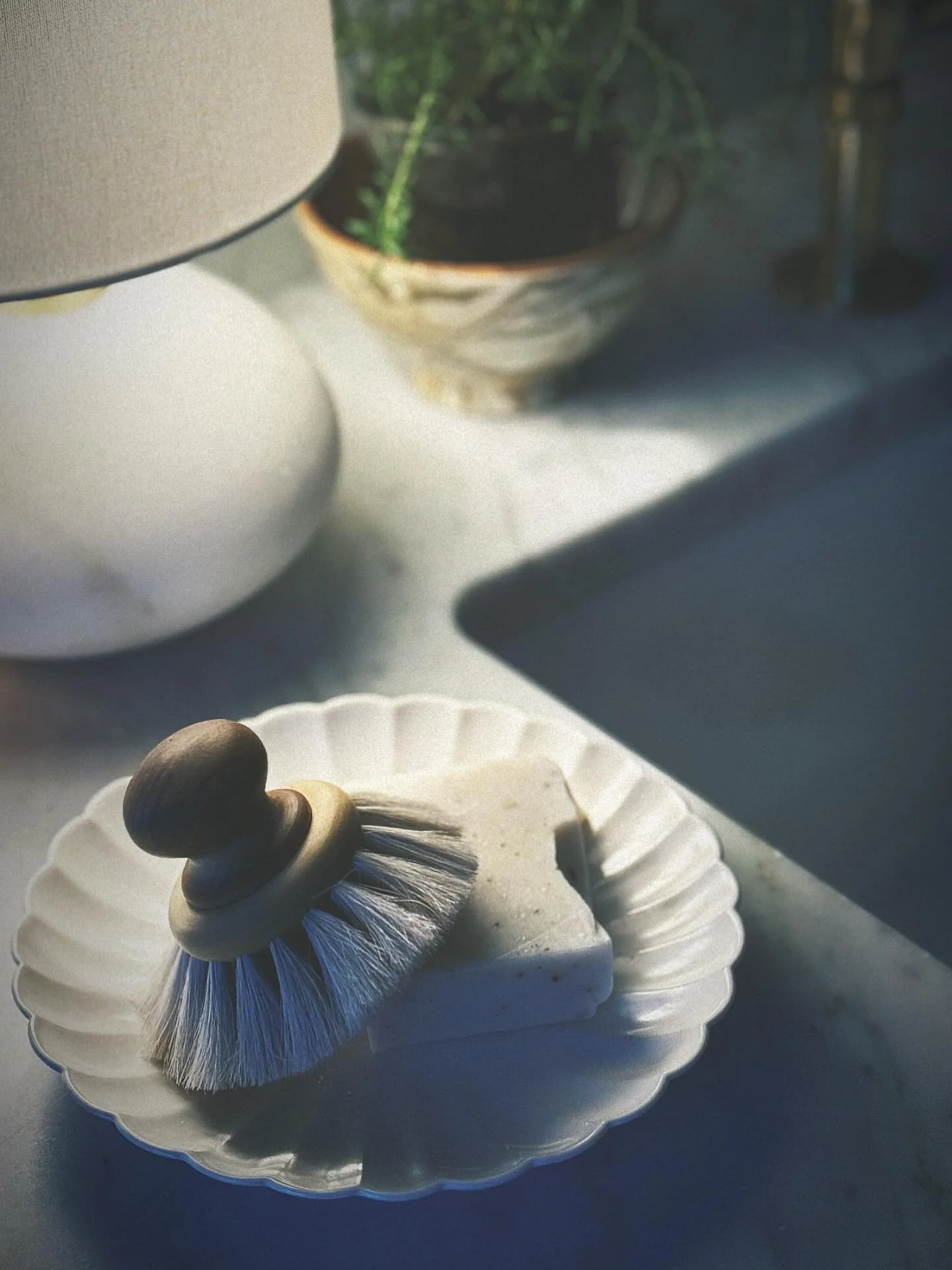 Evening mood in the kitchen, featuring our favorite little lamp, a pretty scalloped dish, complete with handmade soap and dish brush.