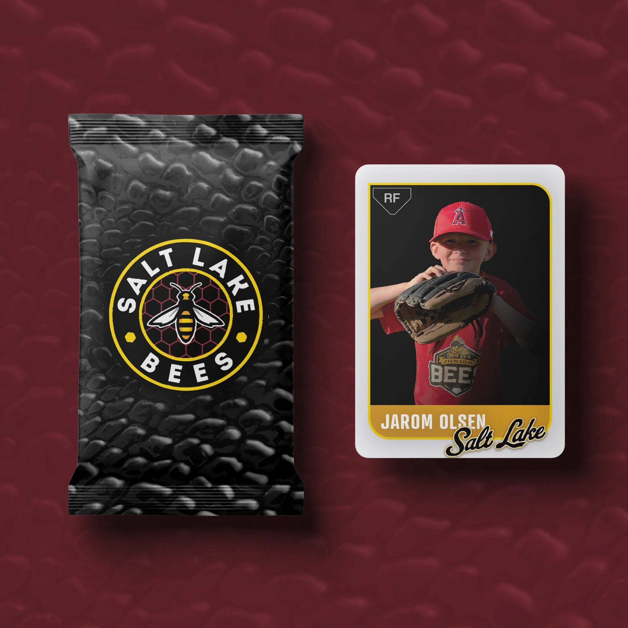 A packet of Salt Lake Bees honey with a logo featuring a bee on a honeycomb background, and a baseball card of a young player named Jarom Olsen holding a glove, wearing a red uniform and cap, with the Salt Lake Bees logo and text.