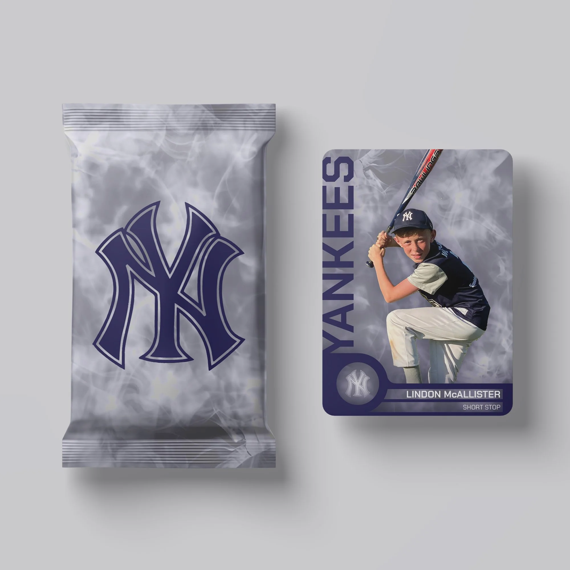 A baseball card featuring a young boy in baseball attire holding a bat, with 'Yankees' written beside him and the name 'Lindon McAllister' at the bottom. Next to the card is a pack of Yankees-themed baseball trading cards with a gray and navy blue de