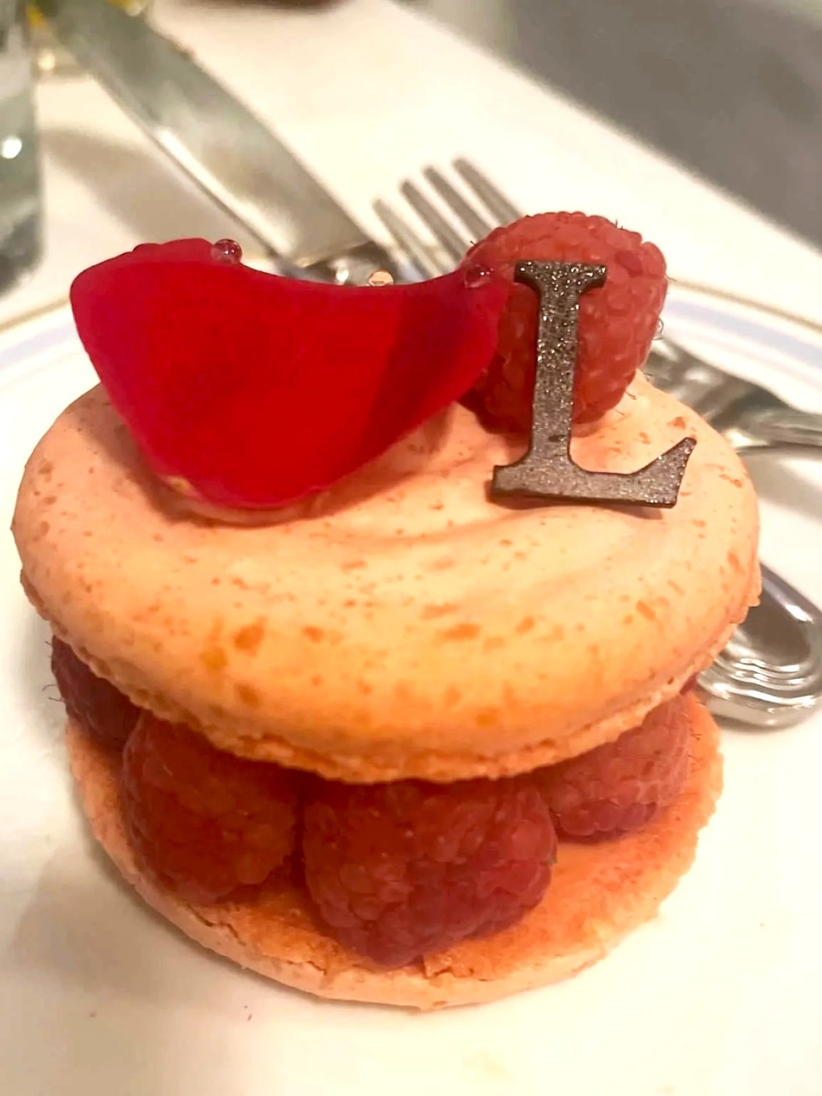 An image of Laduree's famous Ispahan : A large macaron filled with rose petal cream, fresh raspberries, and lychee.