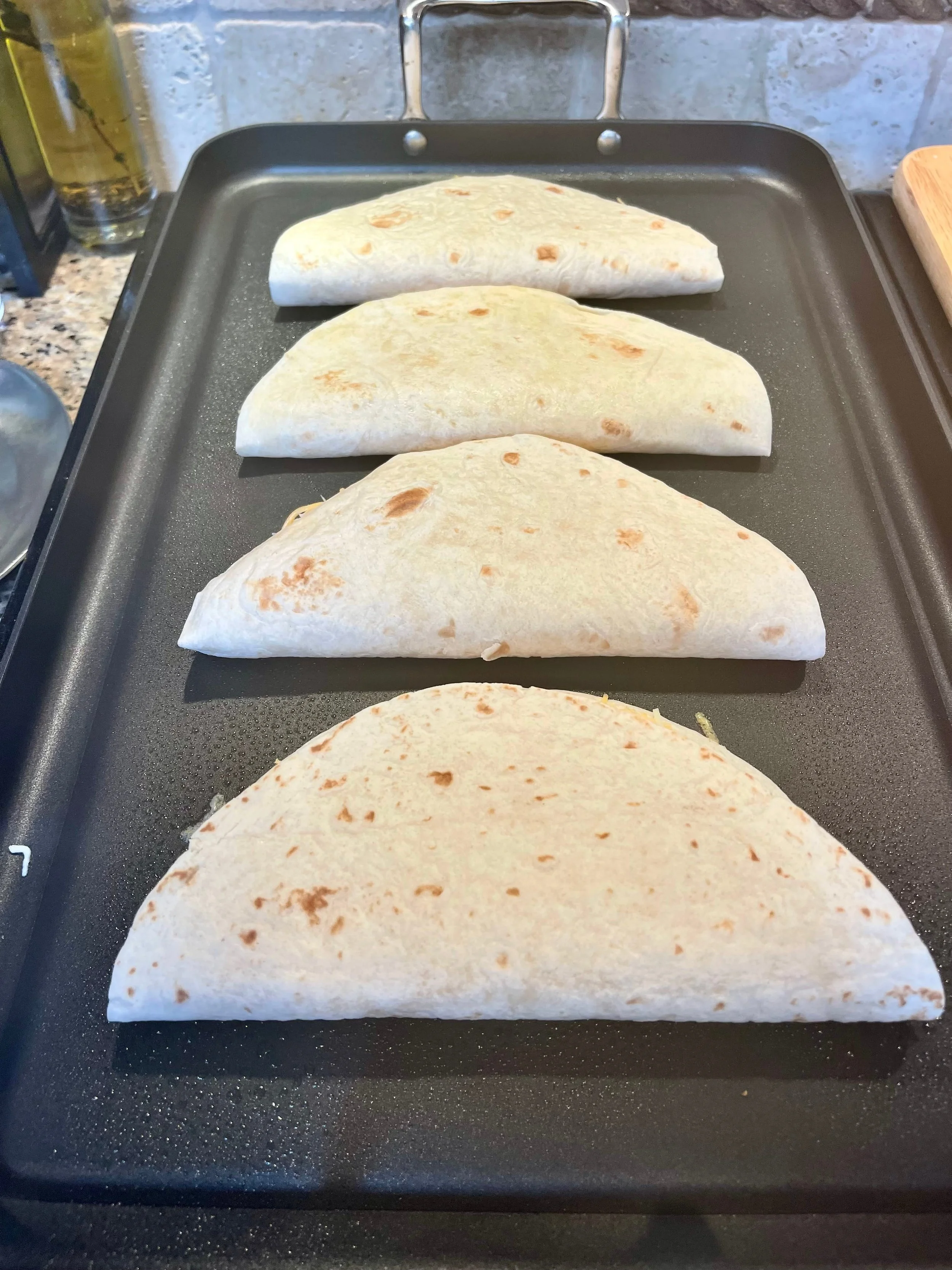 Cooking 4 cheese quesadillas on griddle
