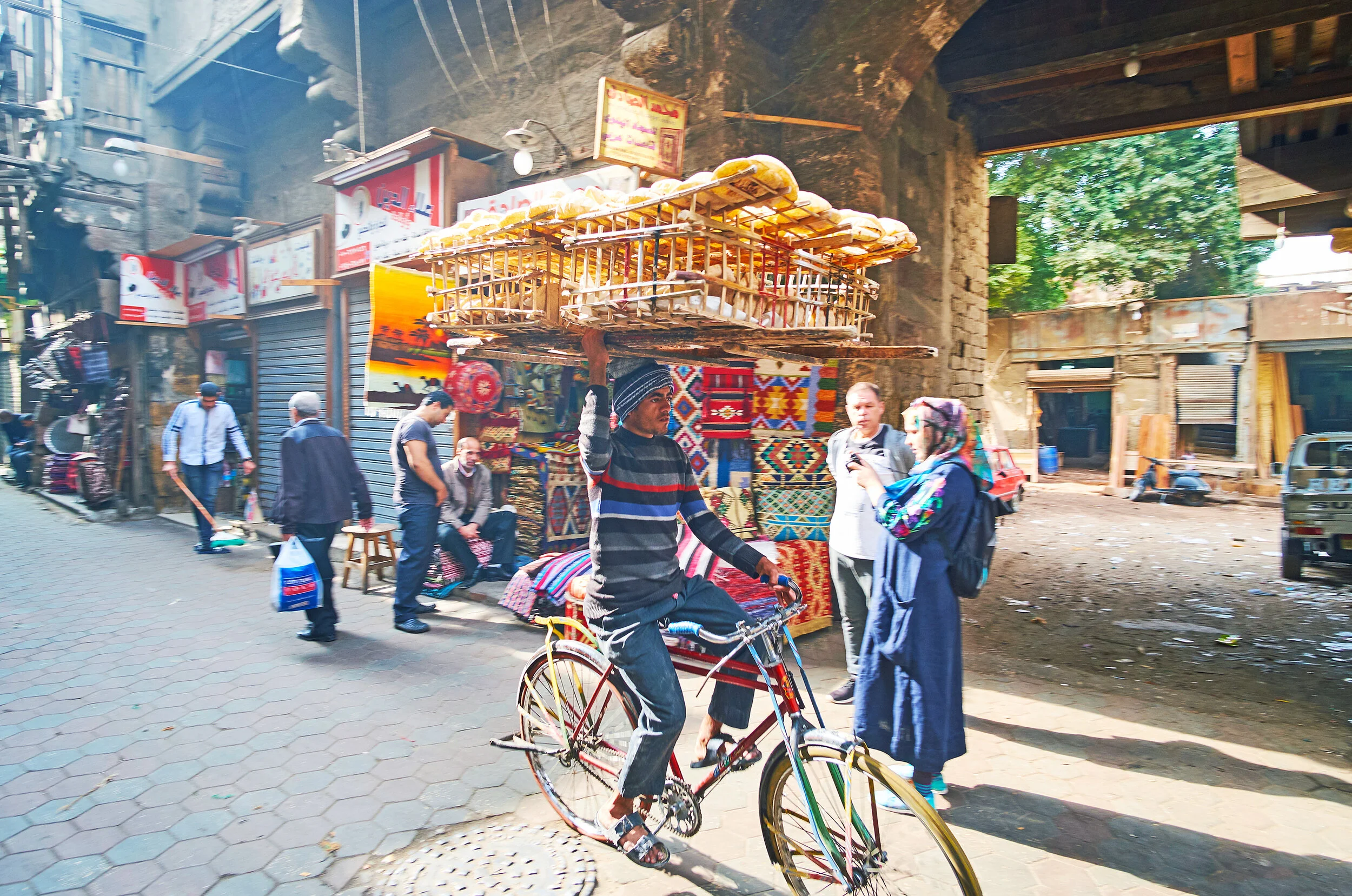 Egyptian street food vendor riding a bike in Cairo.