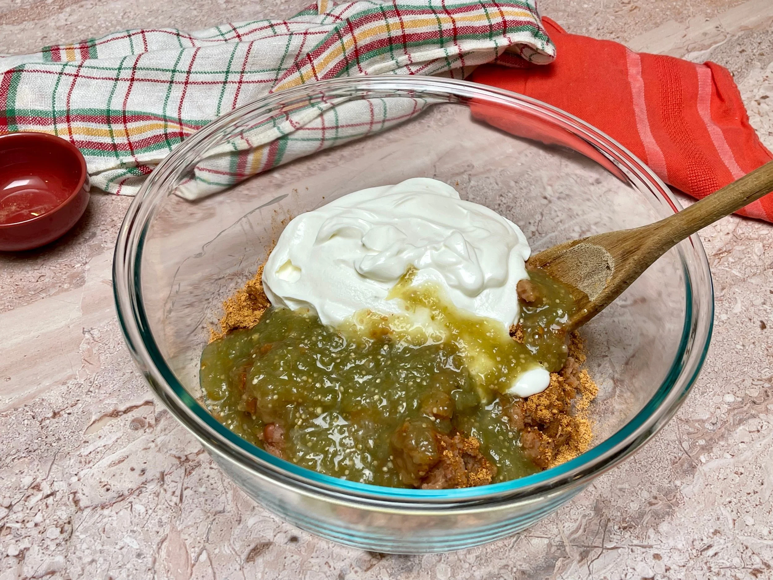 All refried bean dip ingredients except cheese in a bowl