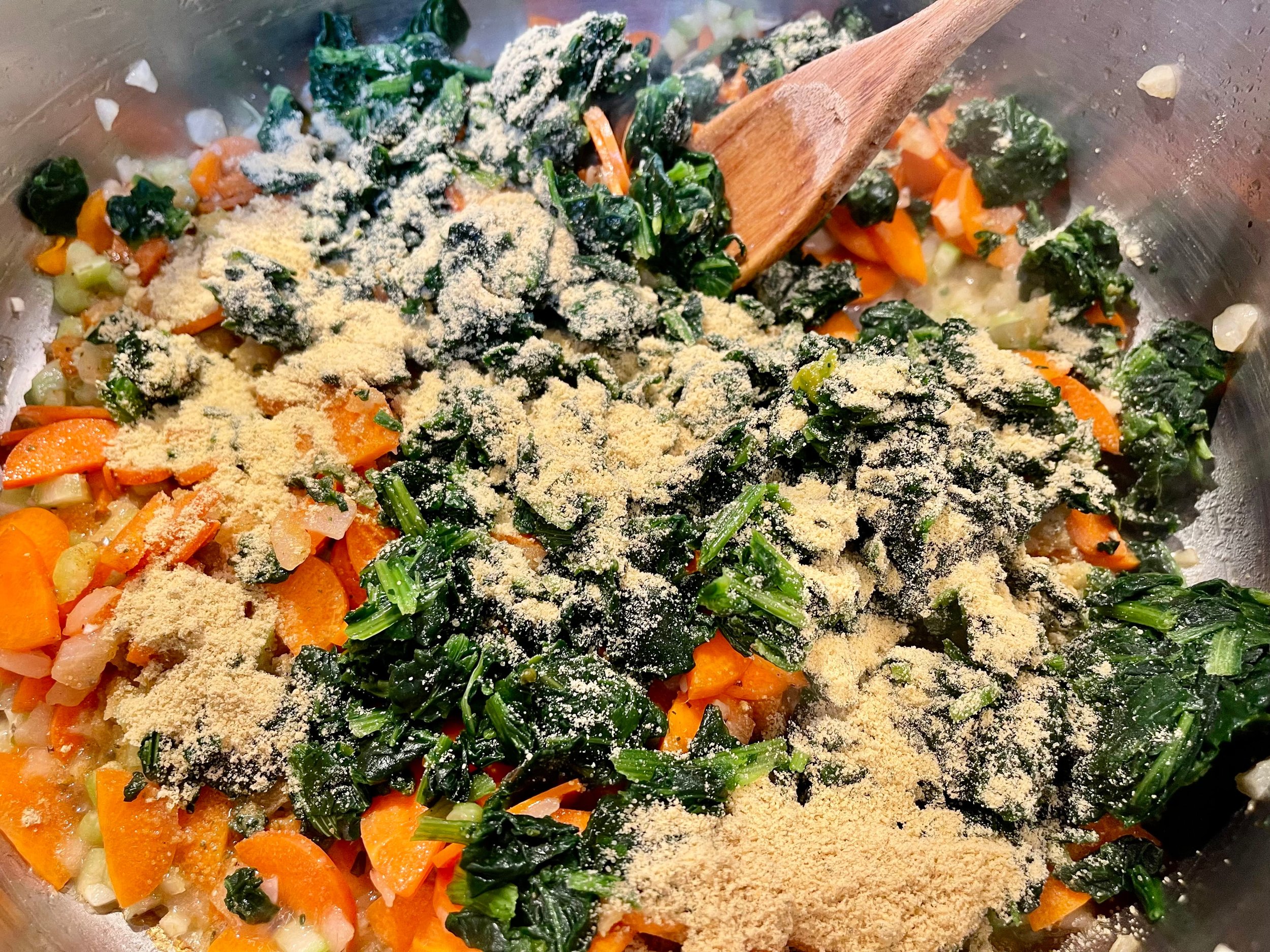 Spinach and bouillon powder added to sautéed veggies