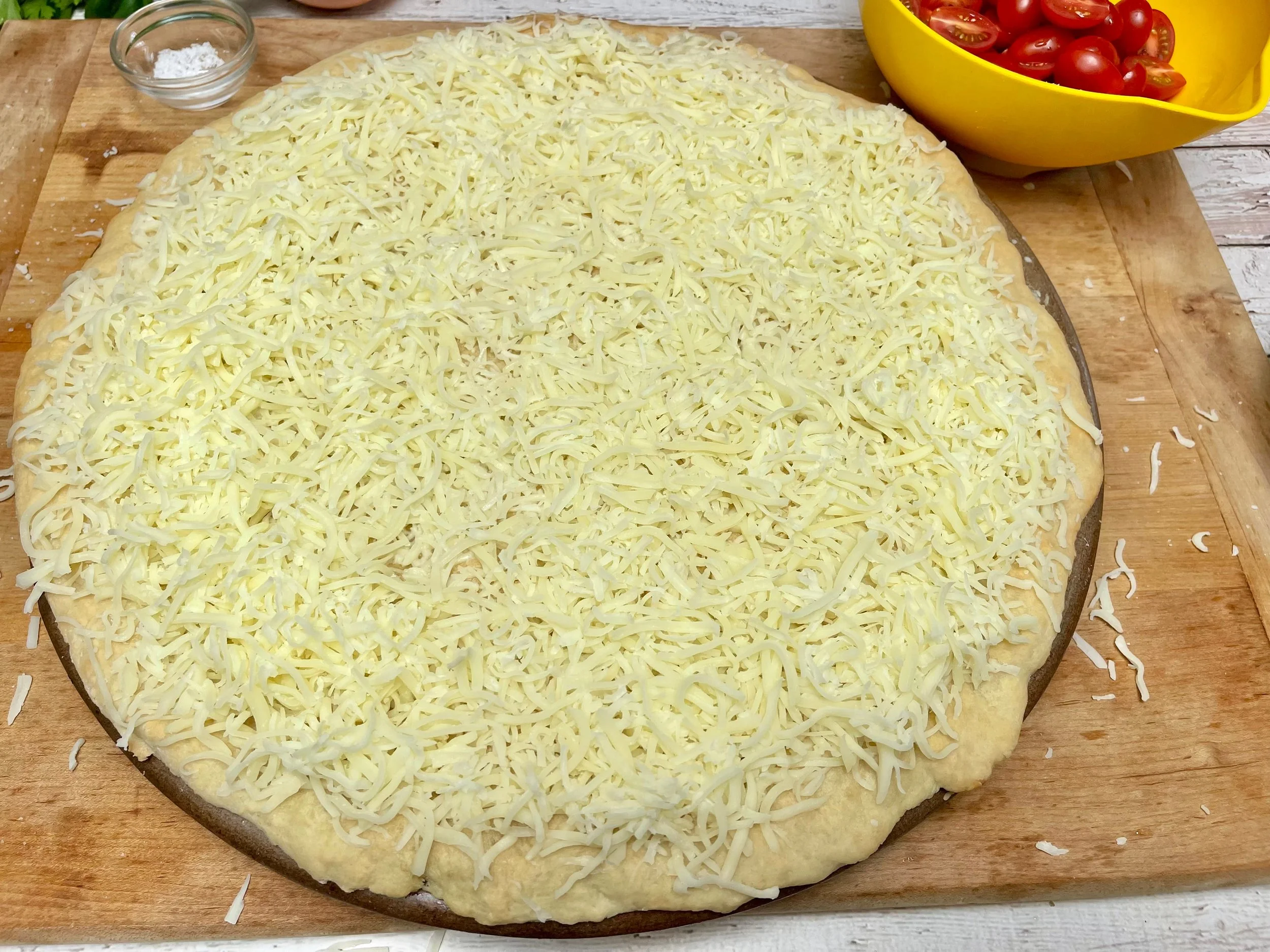 Cooked pizza dough topped with cheese