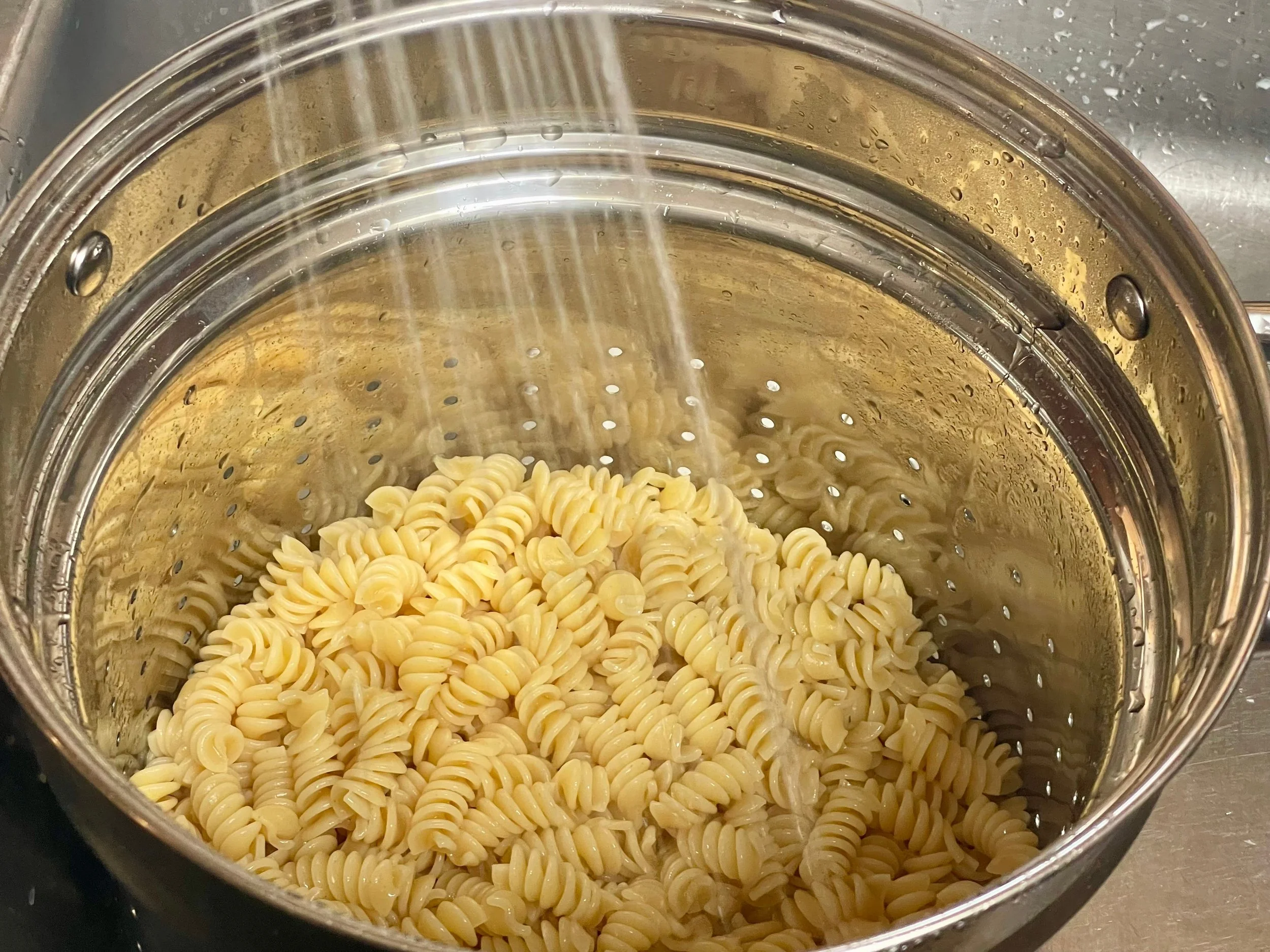 spraying the pasta with cold water