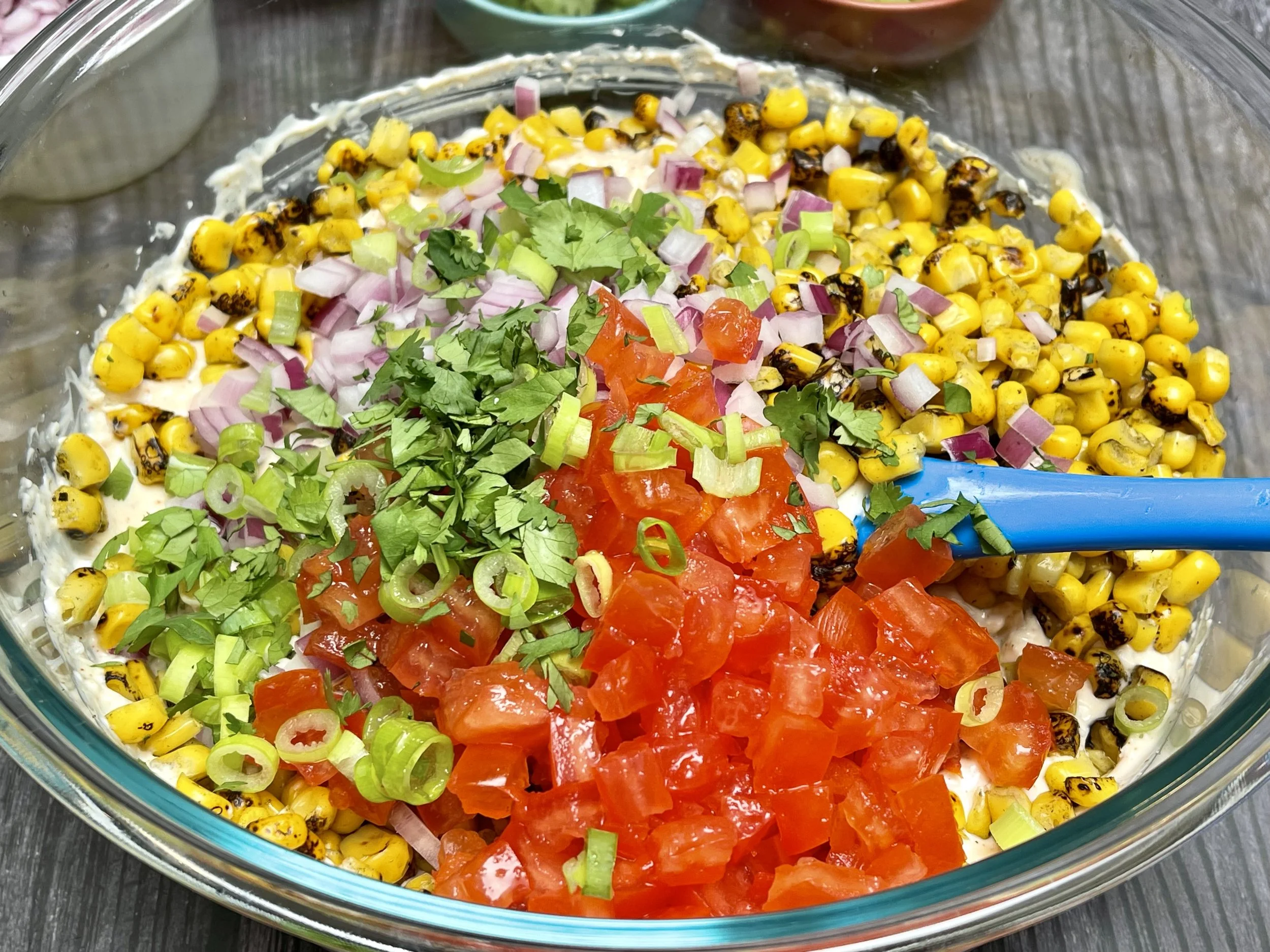 Adding vegetables to the bowl of dressing
