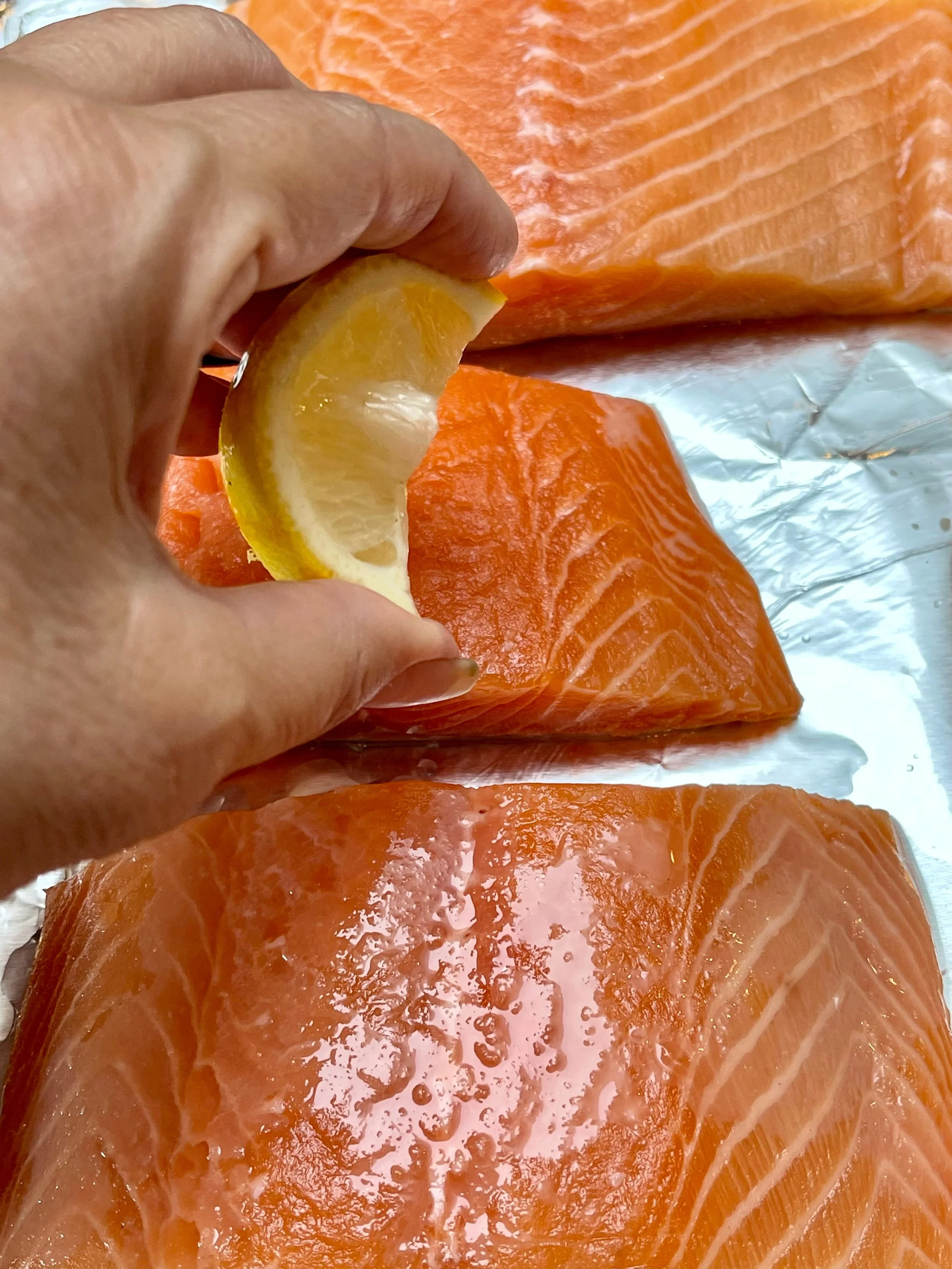 Squeezing lemon juice on salmon