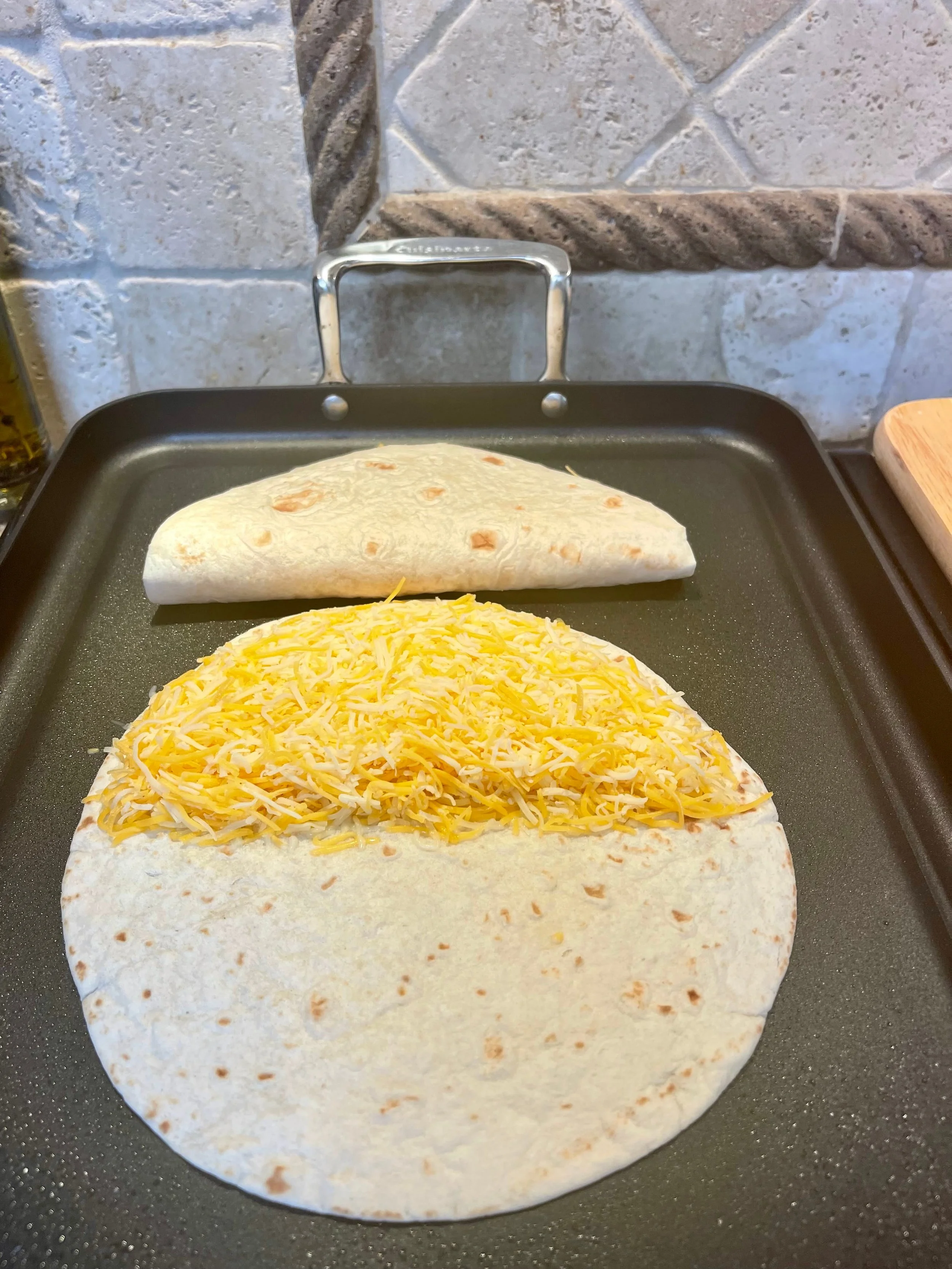 Cheese on tortilla on griddle