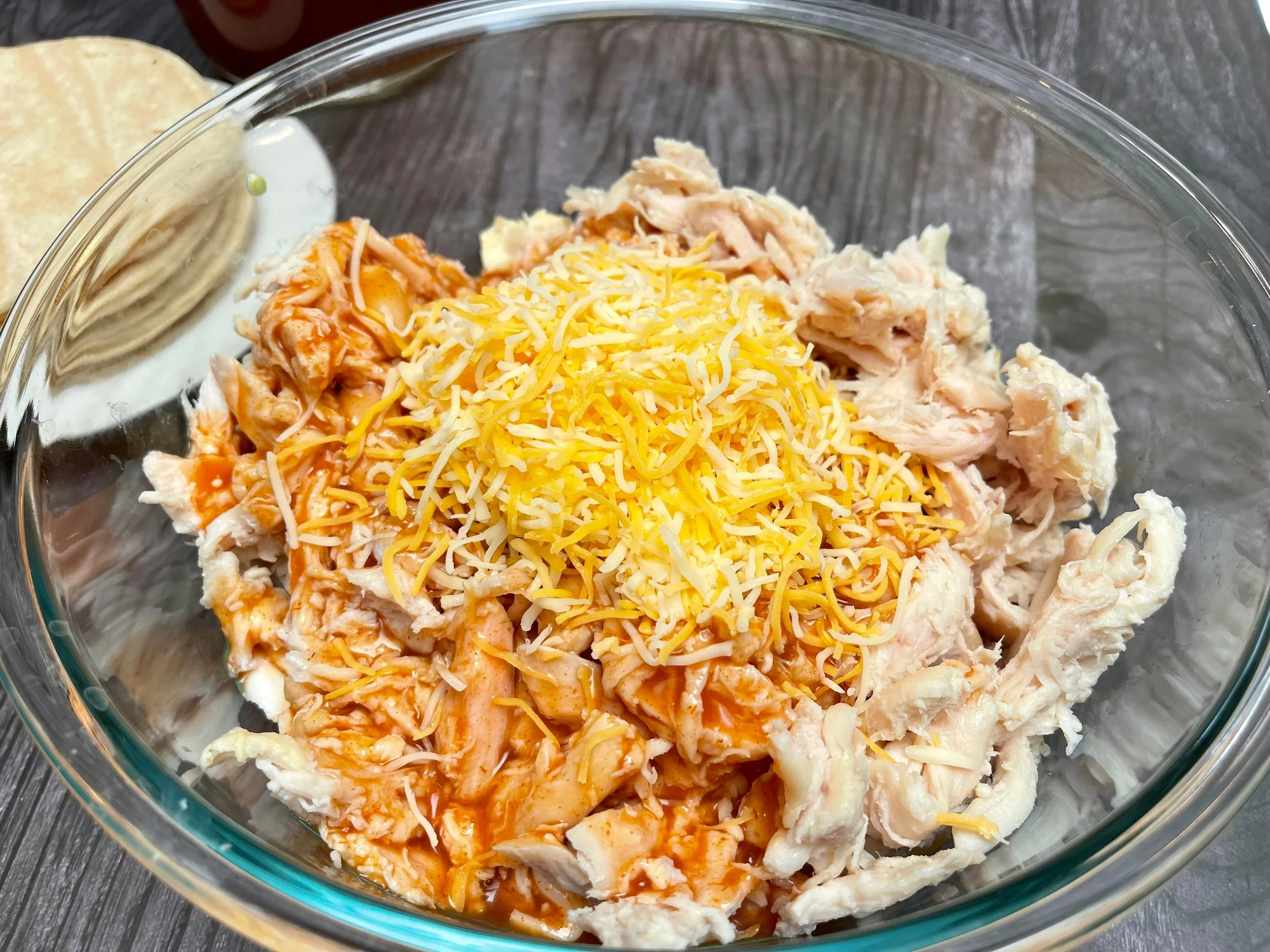 mixing chicken, sauce, and cheese together