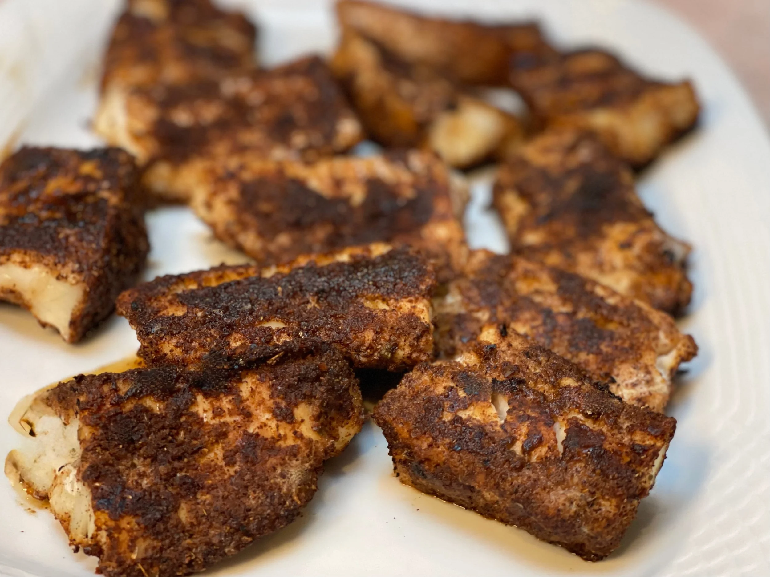 Cooked blackened fish on platter