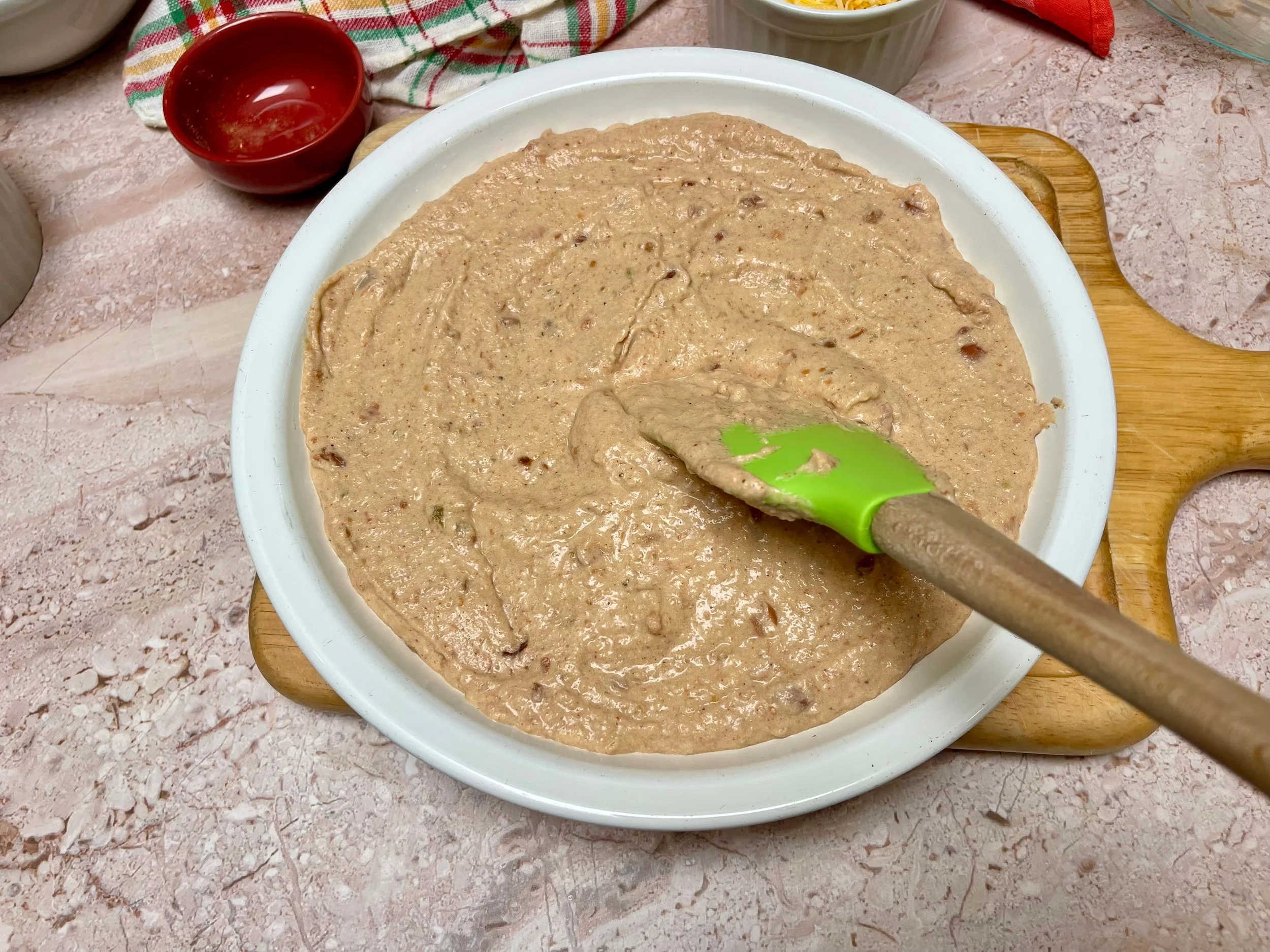 Spreading refried bean dip base into baking dish