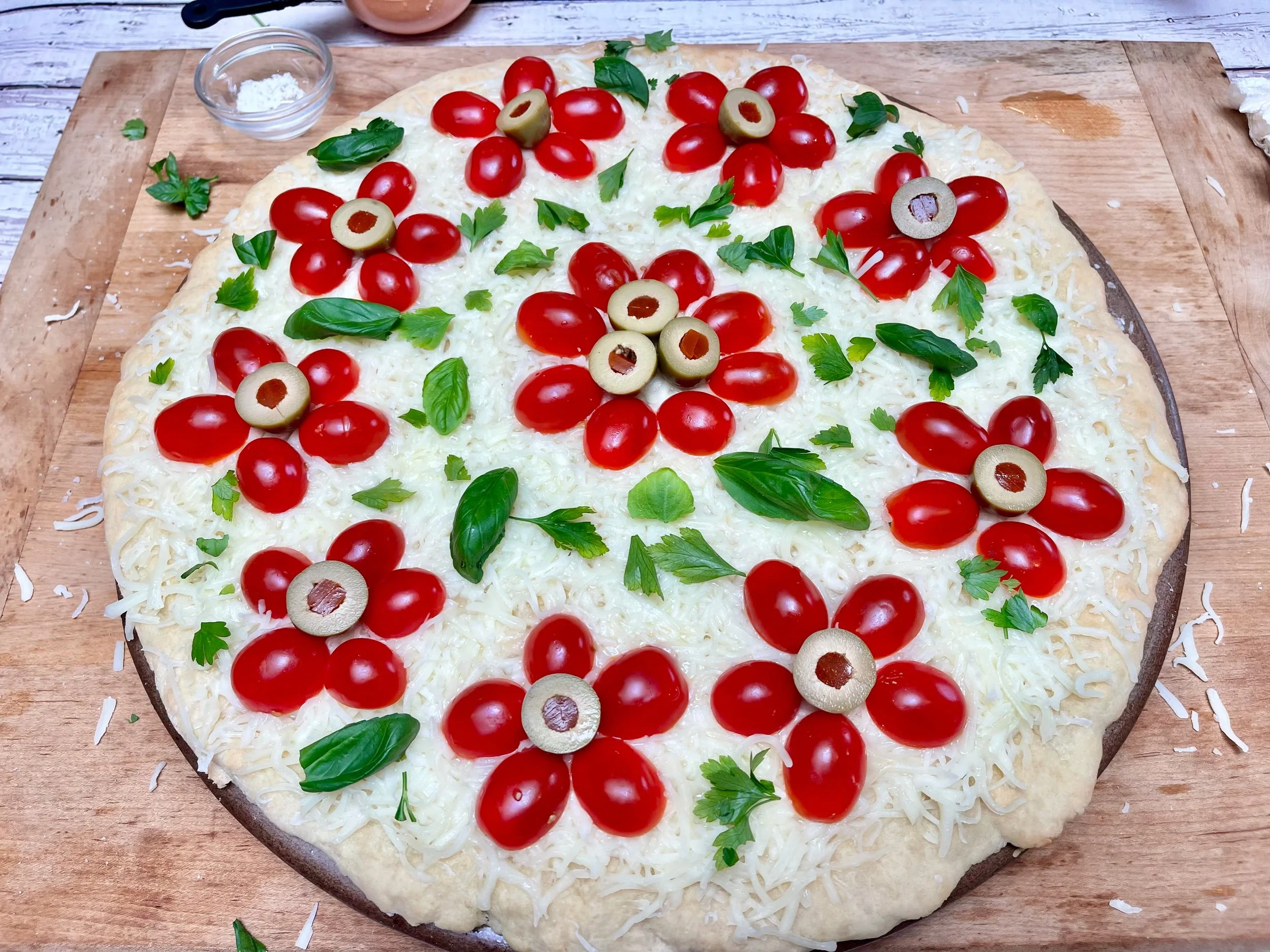 Olives, parsley, and basil added to the cherry tomato pizza