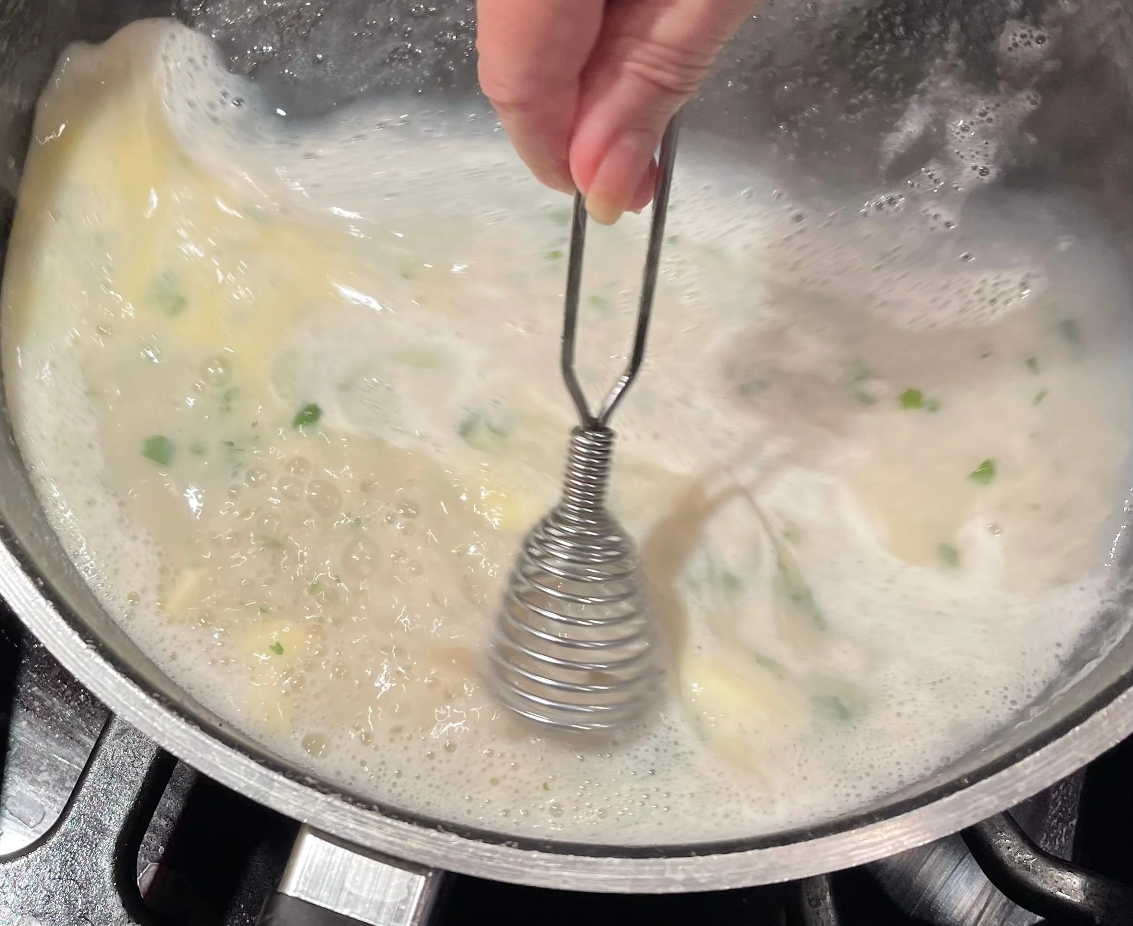 Whisking the butter into the lobster sauce
