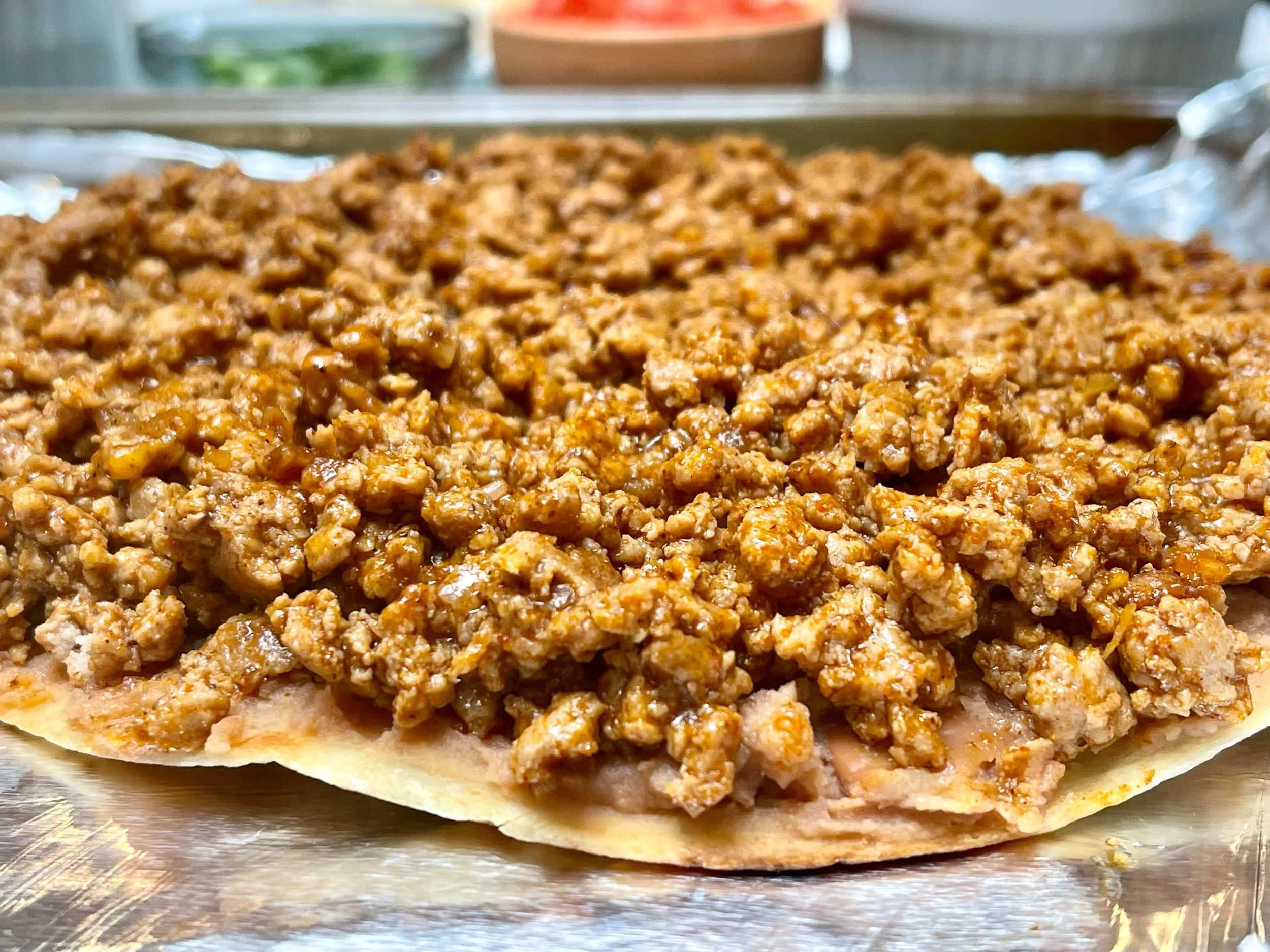 Topping beans with cooked seasoned ground meat