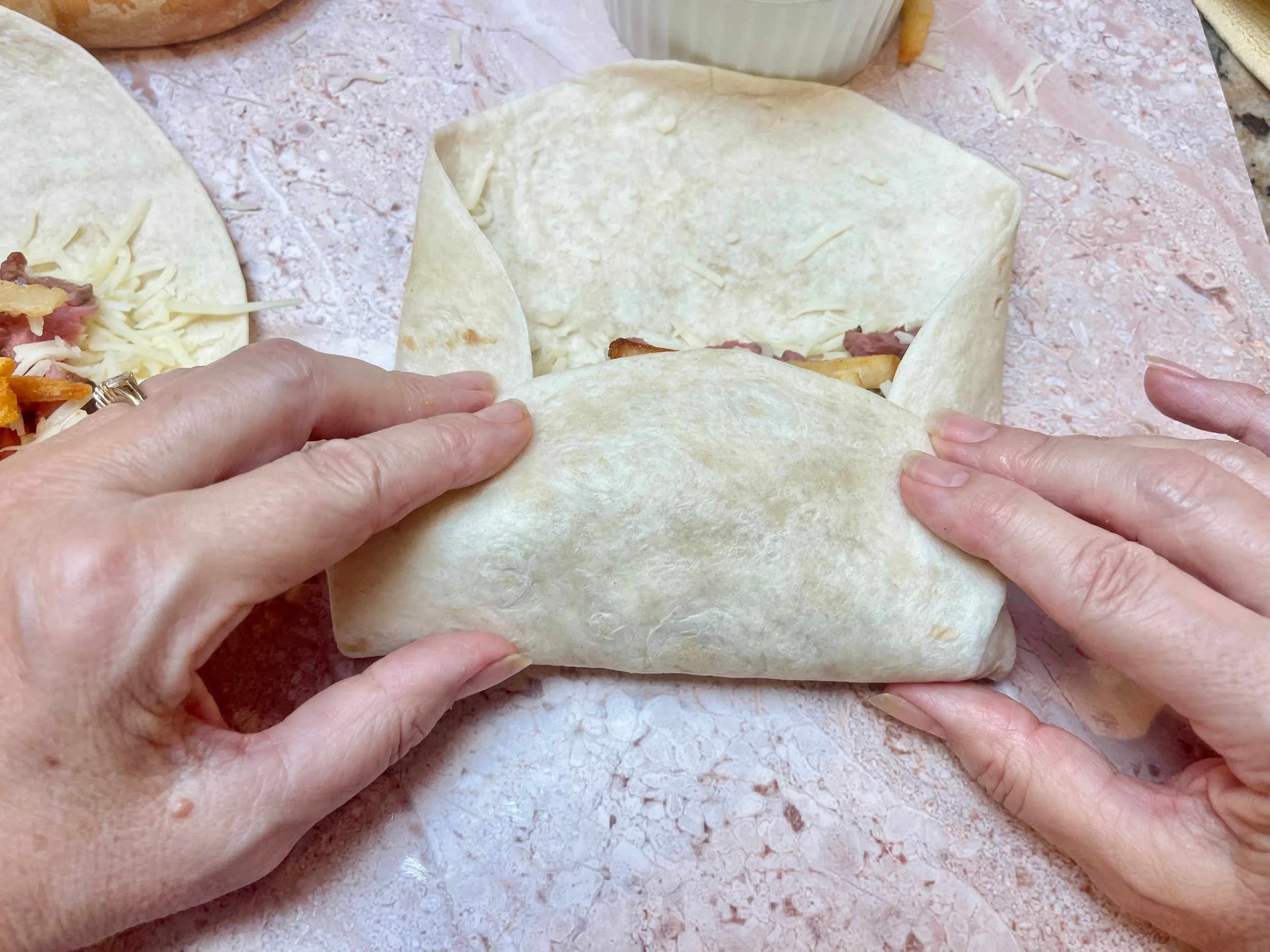 Rolling the flour tortilla into a burrito