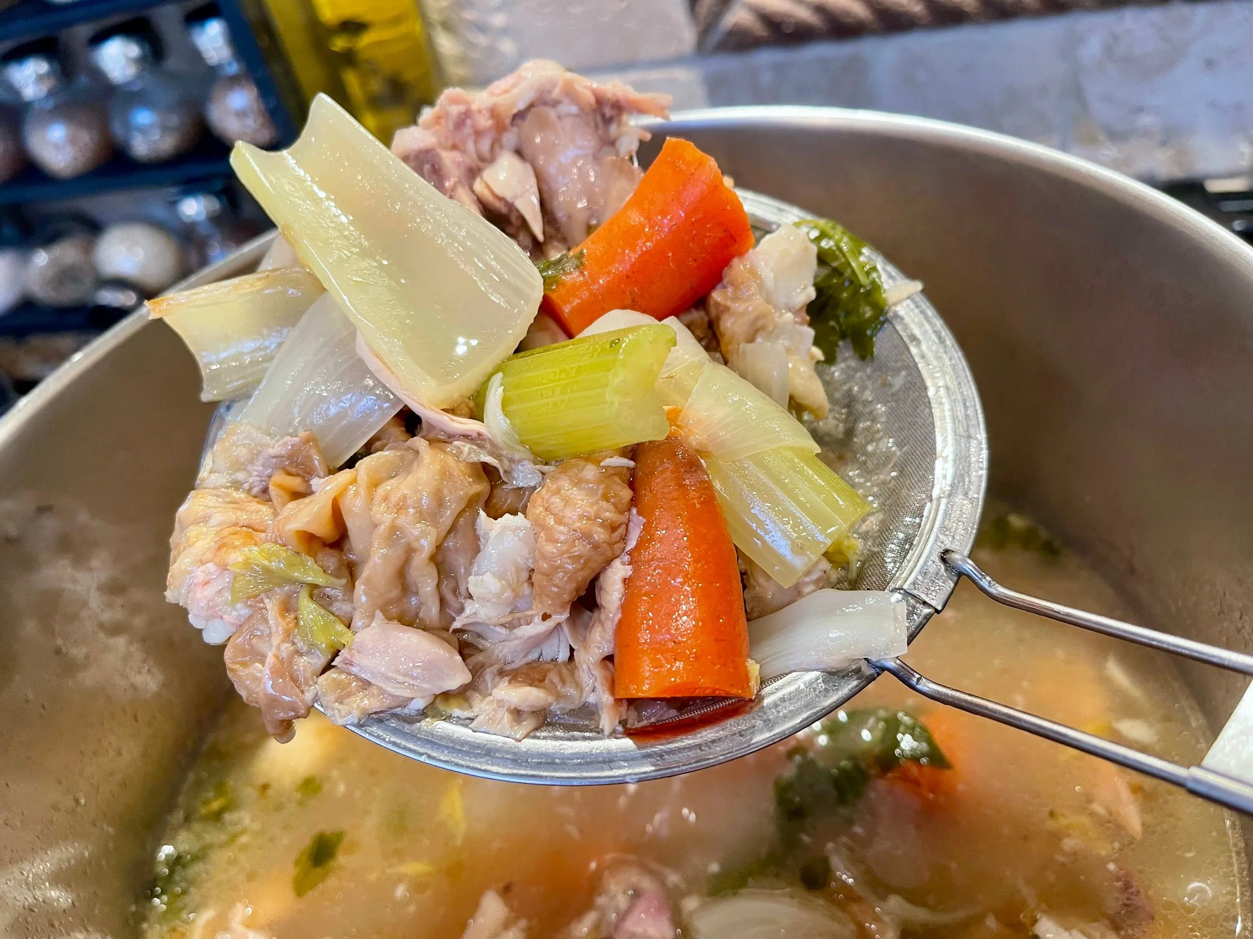 removing the large pieces of bones and veg from the stock