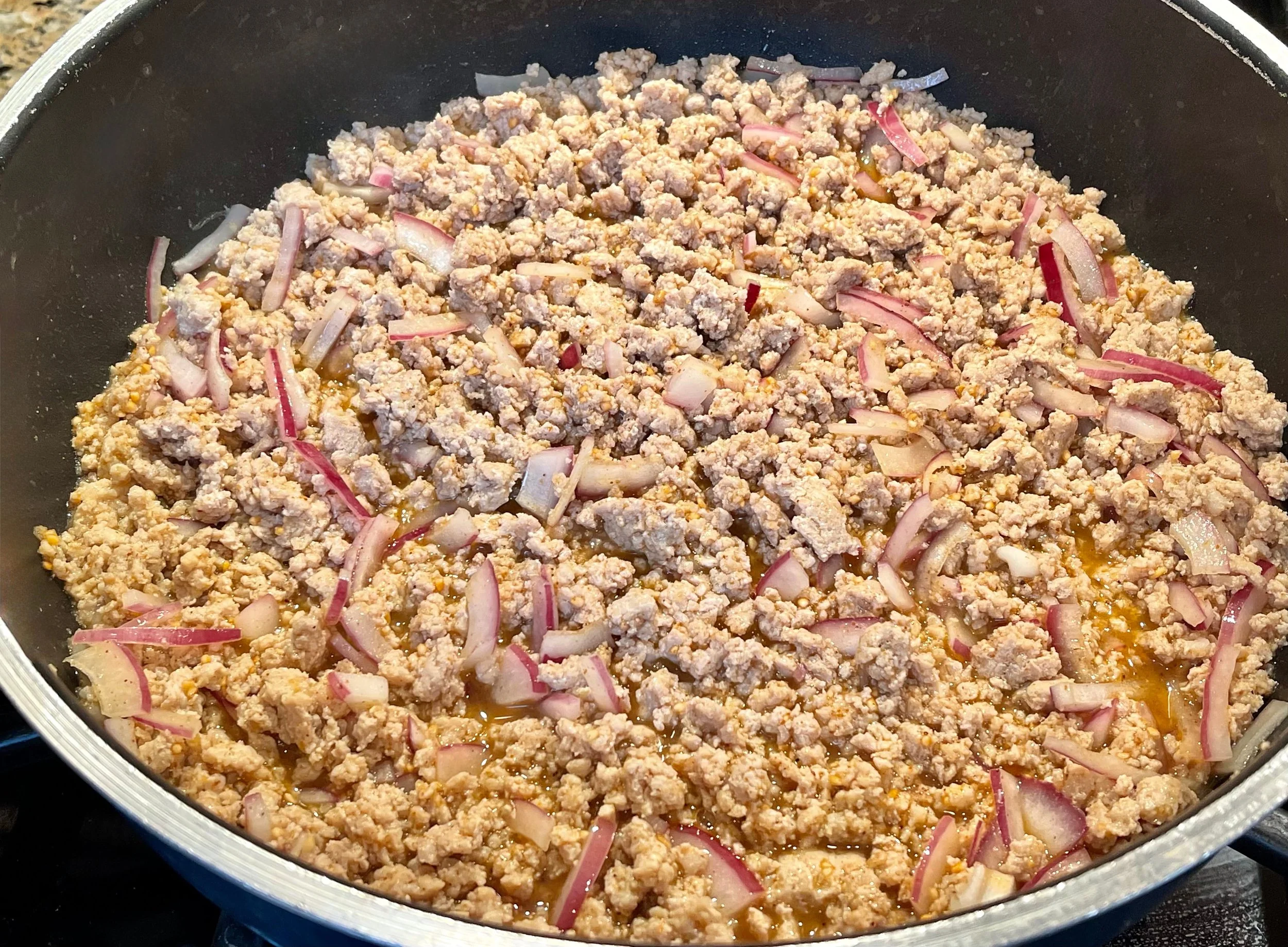 adding onions to Thai chicken larb