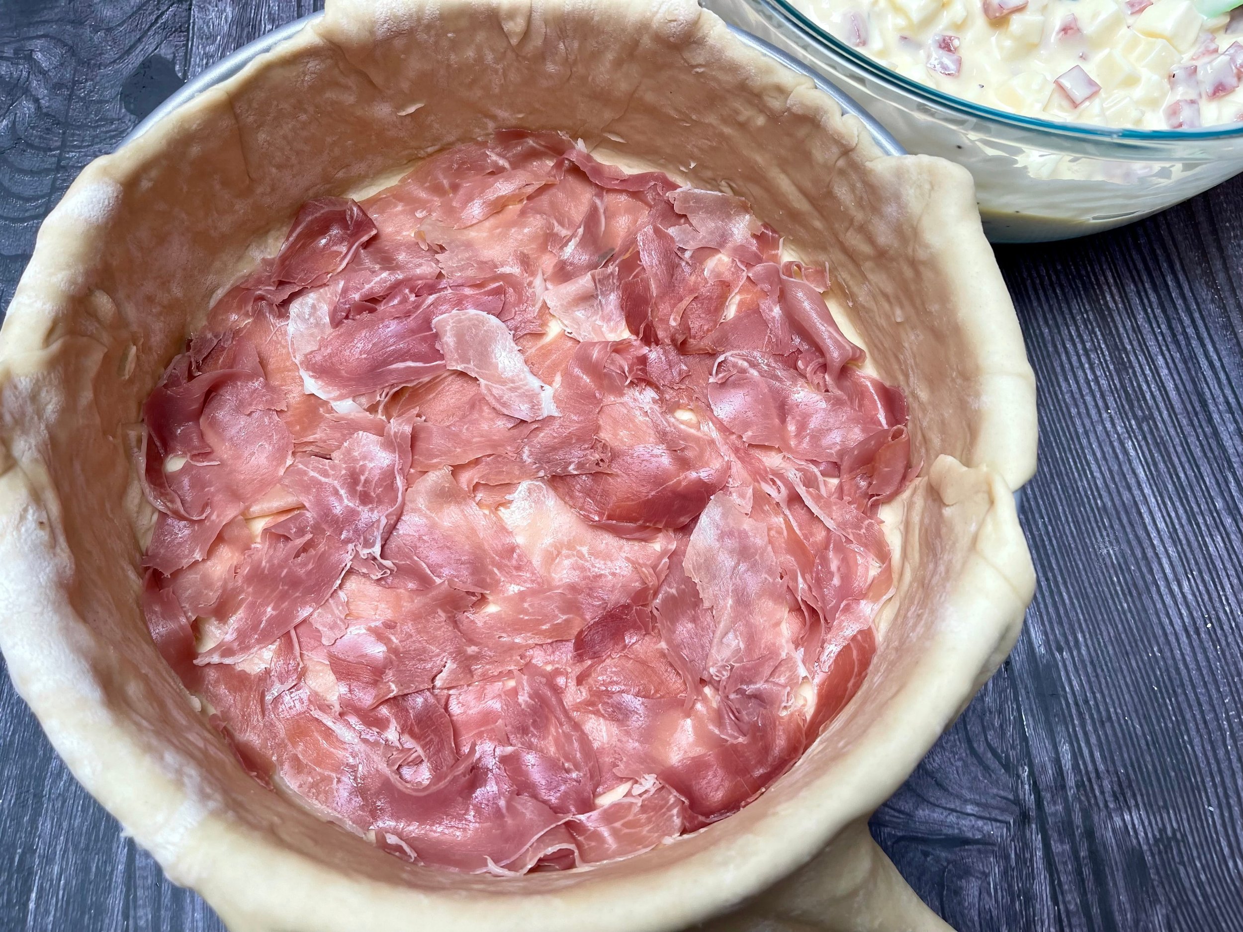 layer of prosciutto on bottom of pie