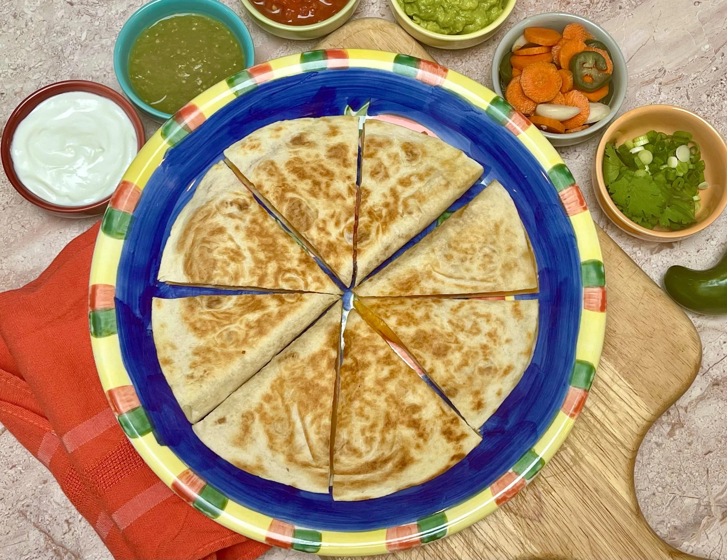 Cheese quesadillas on a platter with salsas and guacamole