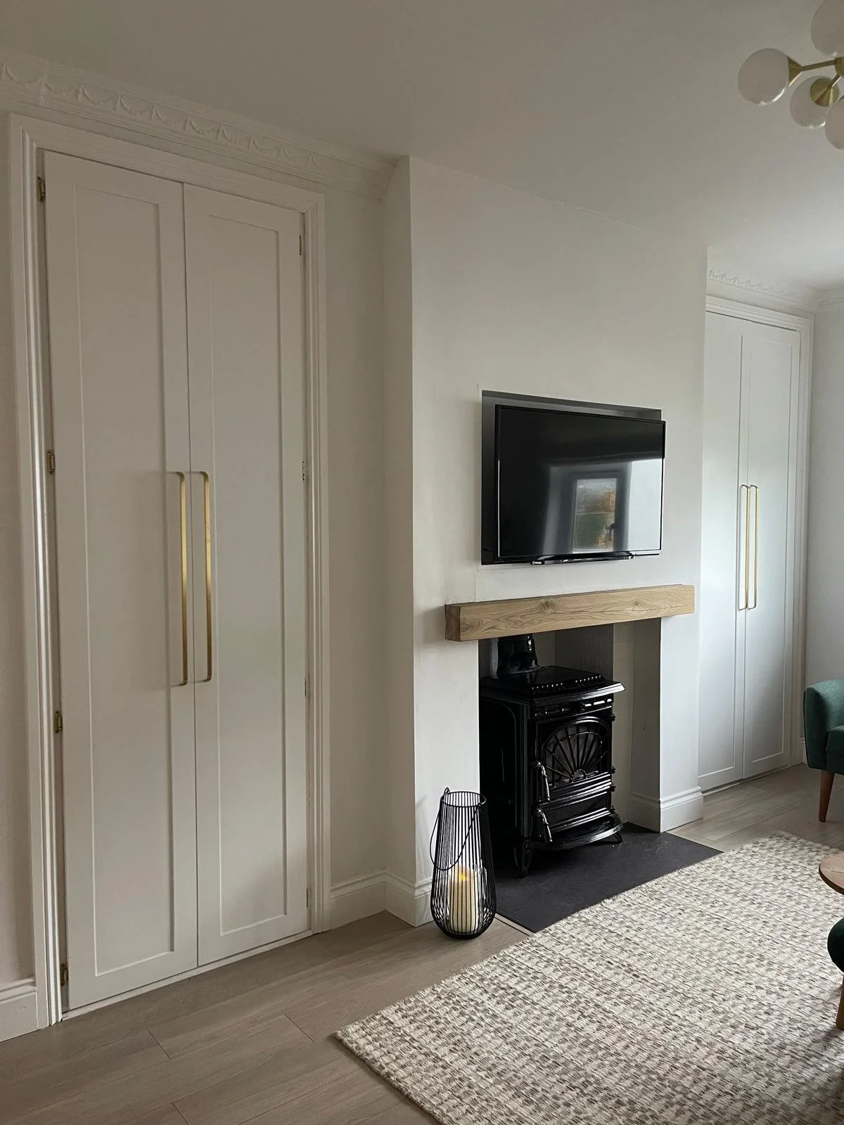 Room detail with fitted wall panelling, a black fireplace, and a soft neutral palette for a more polished finish.