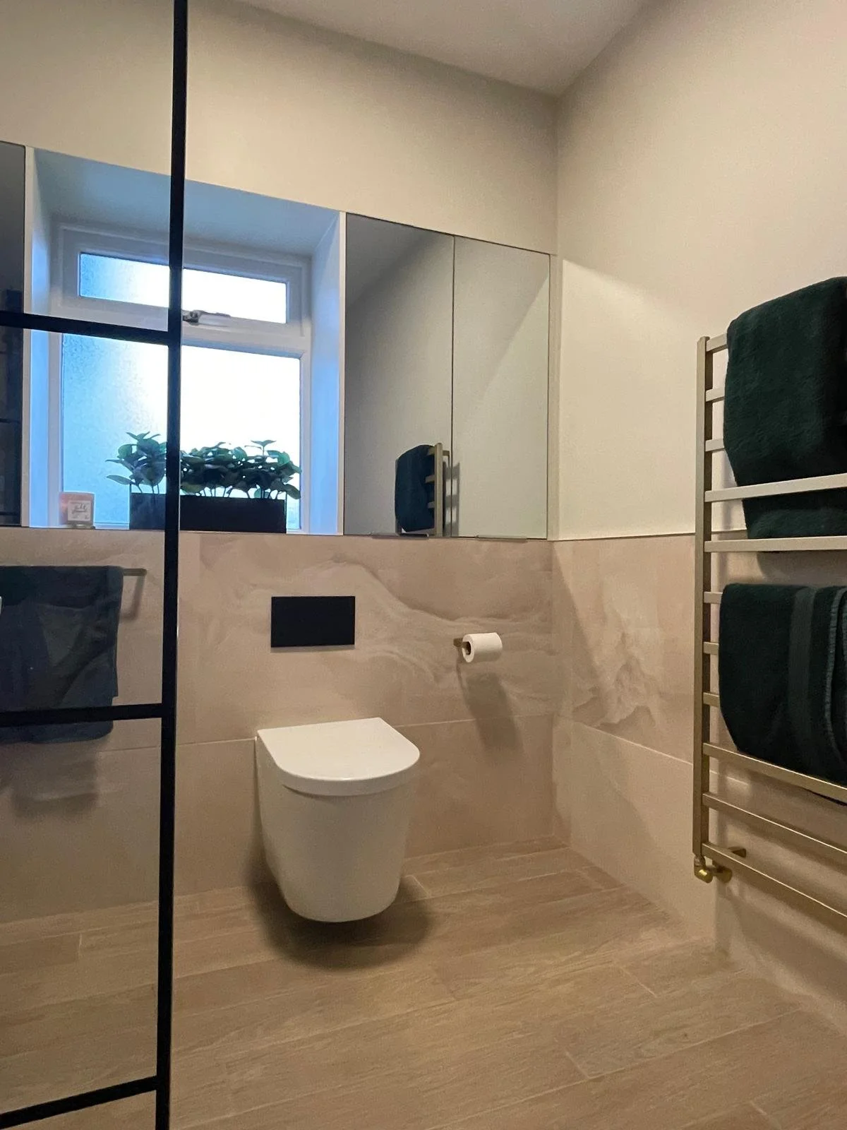 Contemporary bathroom with warm neutral tiling, clean lines, and a calmer, more polished finish.