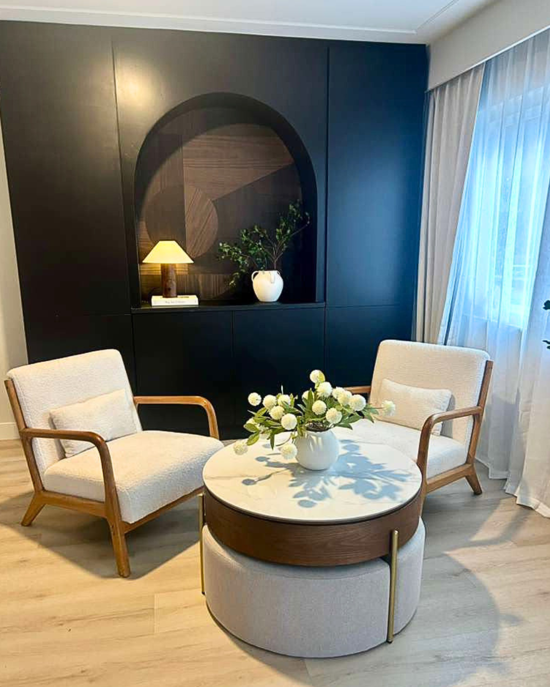 Cosy seating corner with a dark feature wall and layered lighting.