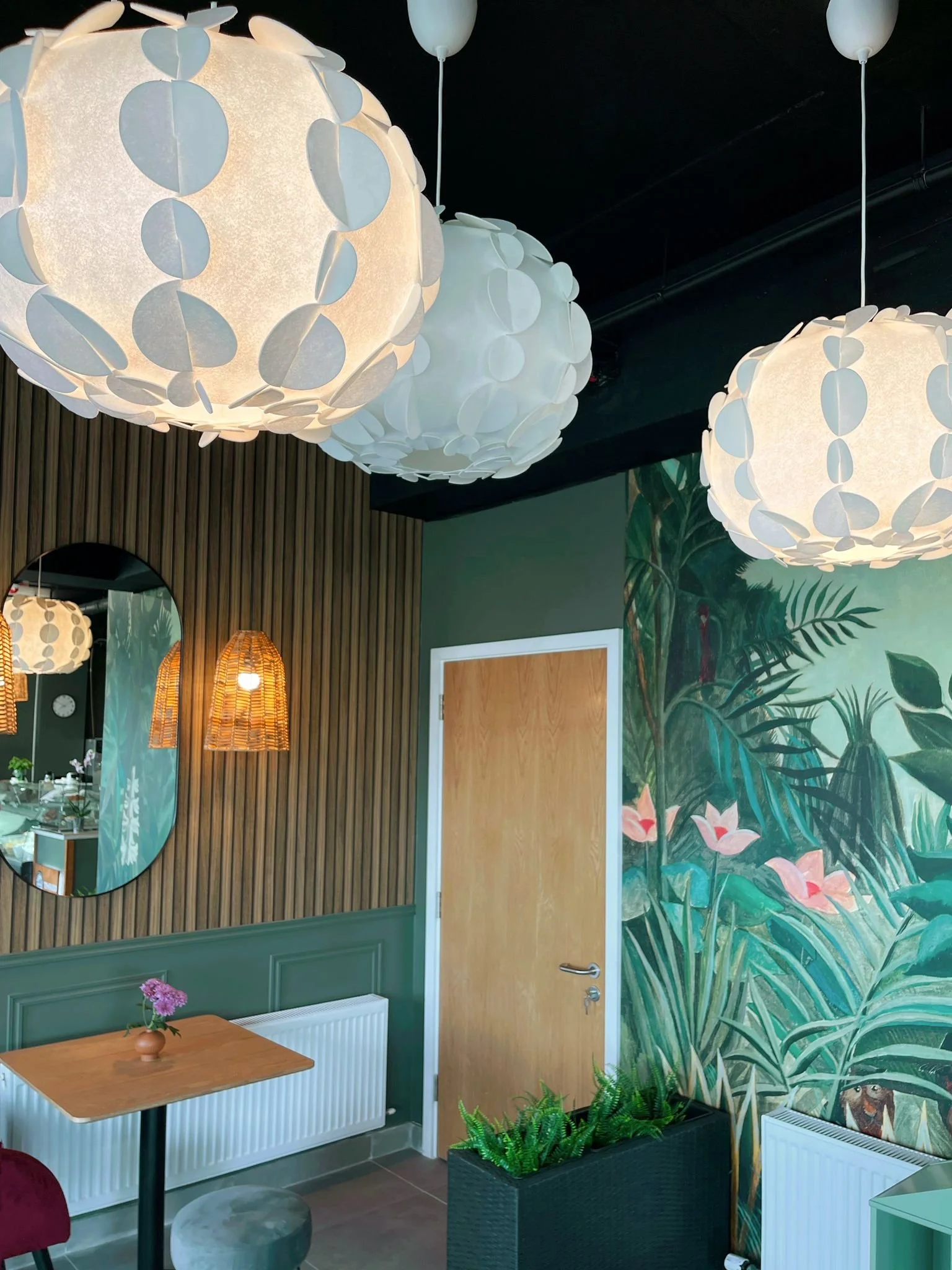 Detail view of the tropical feature wall with layered lighting, timber texture, and joinery.