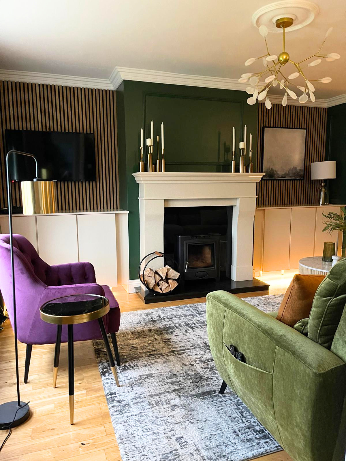 Living room view with a fireplace, purple accent chair, and rich layered colour for a more characterful, inviting finish.